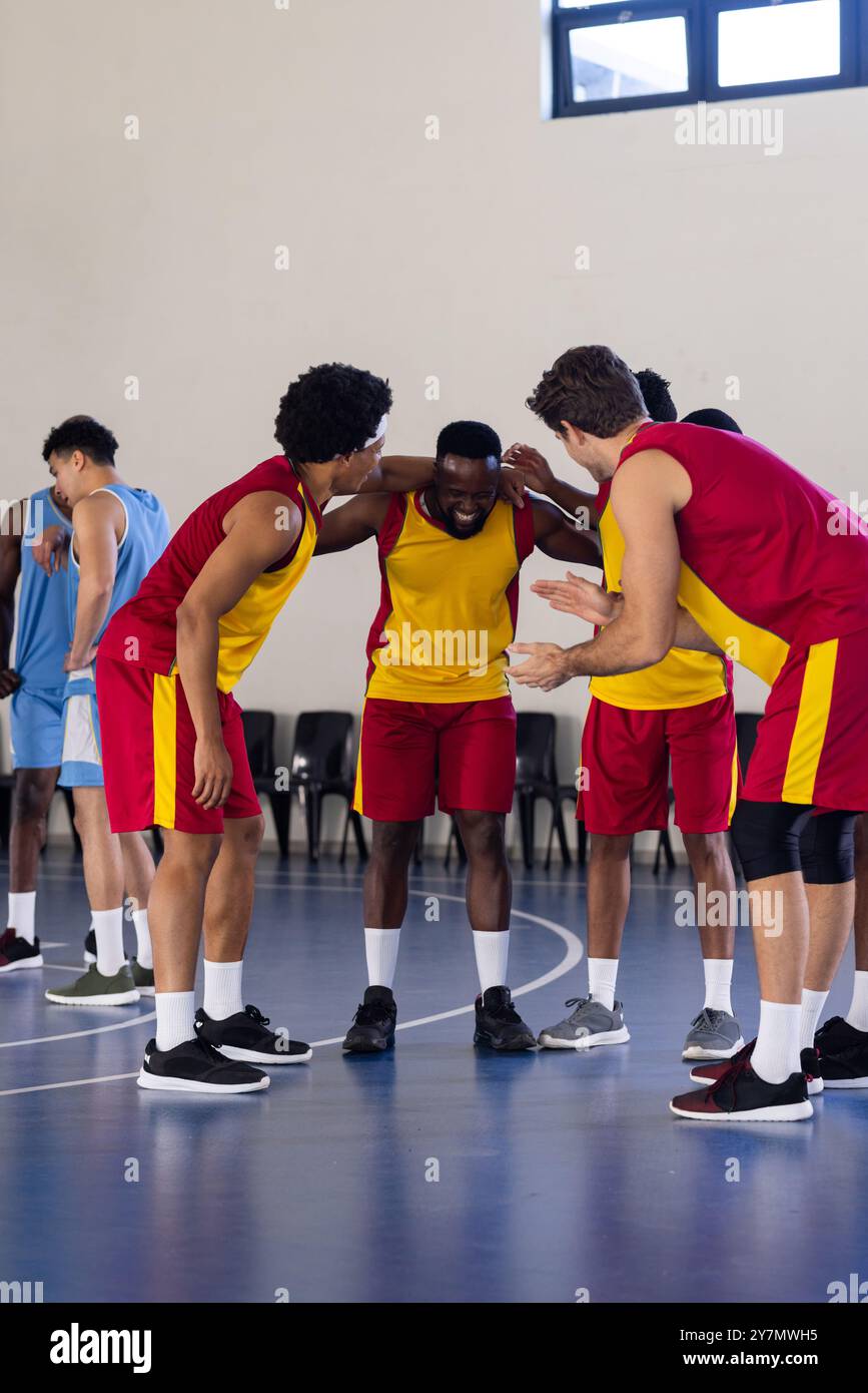 Divers joueurs de basket-ball en caucus d'équipe sur le terrain, se préparant à la stratégie de jeu Banque D'Images