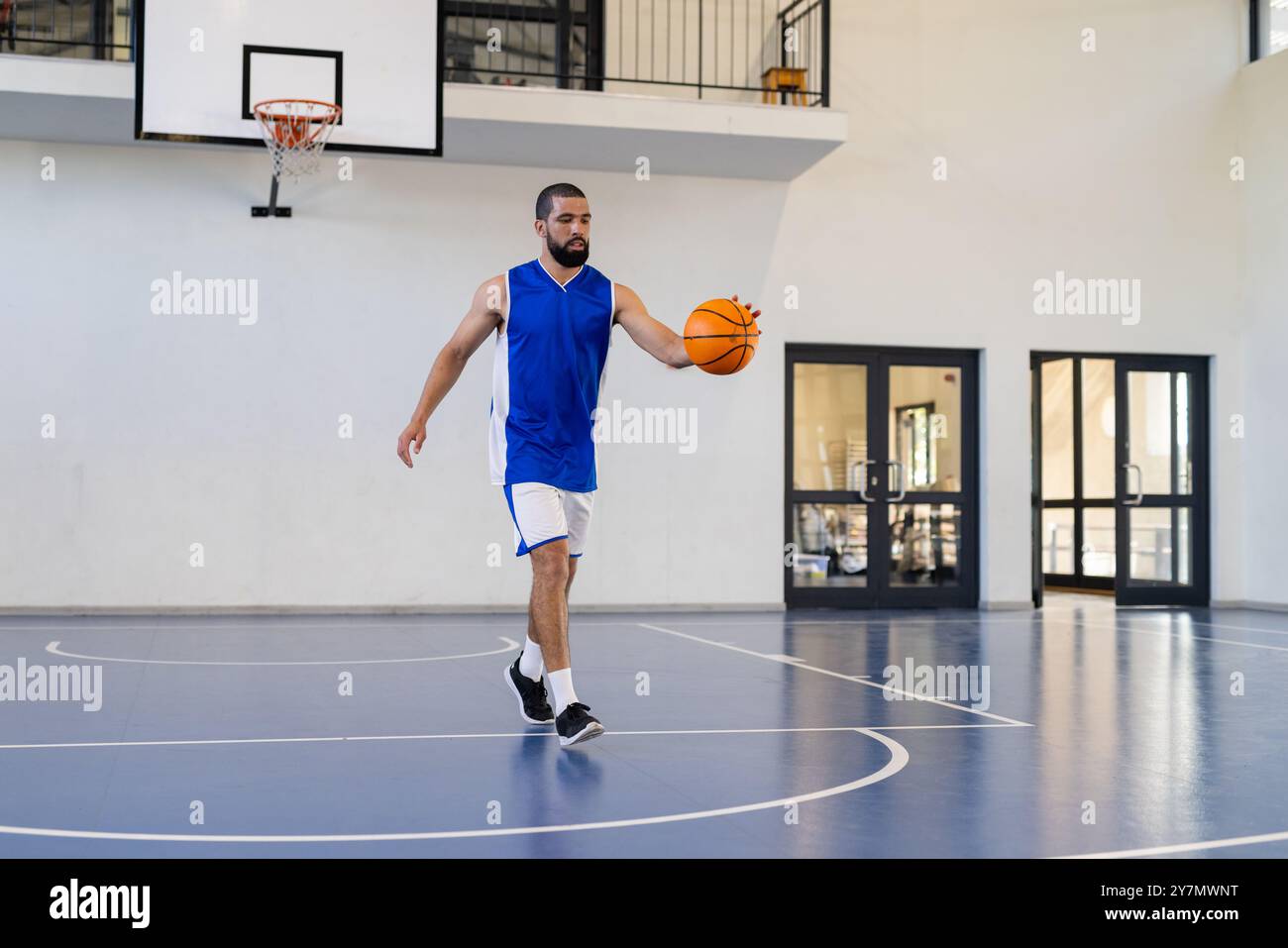 Dribble basketball, homme pratiquant sur terrain couvert, se concentrant sur les compétences Banque D'Images