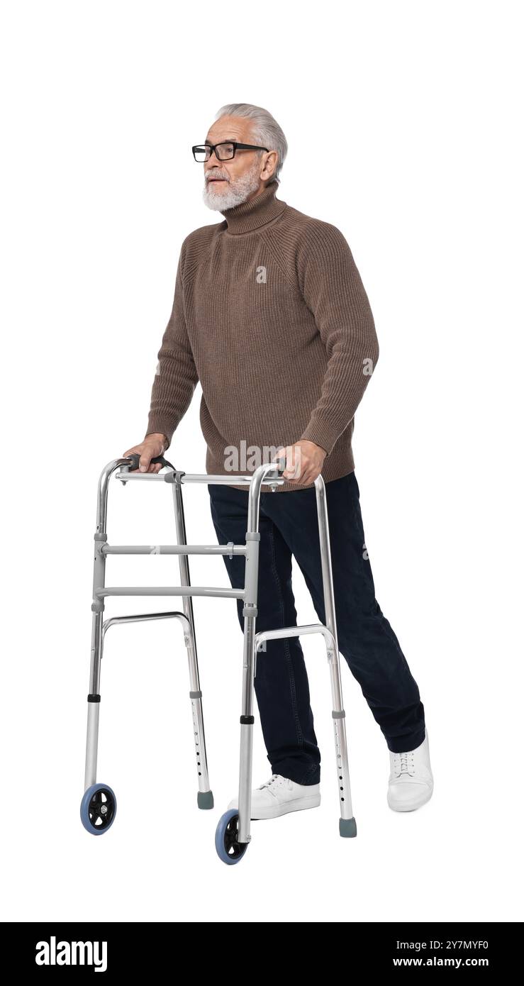 Homme senior utilisant le cadre de marche sur fond blanc Banque D'Images