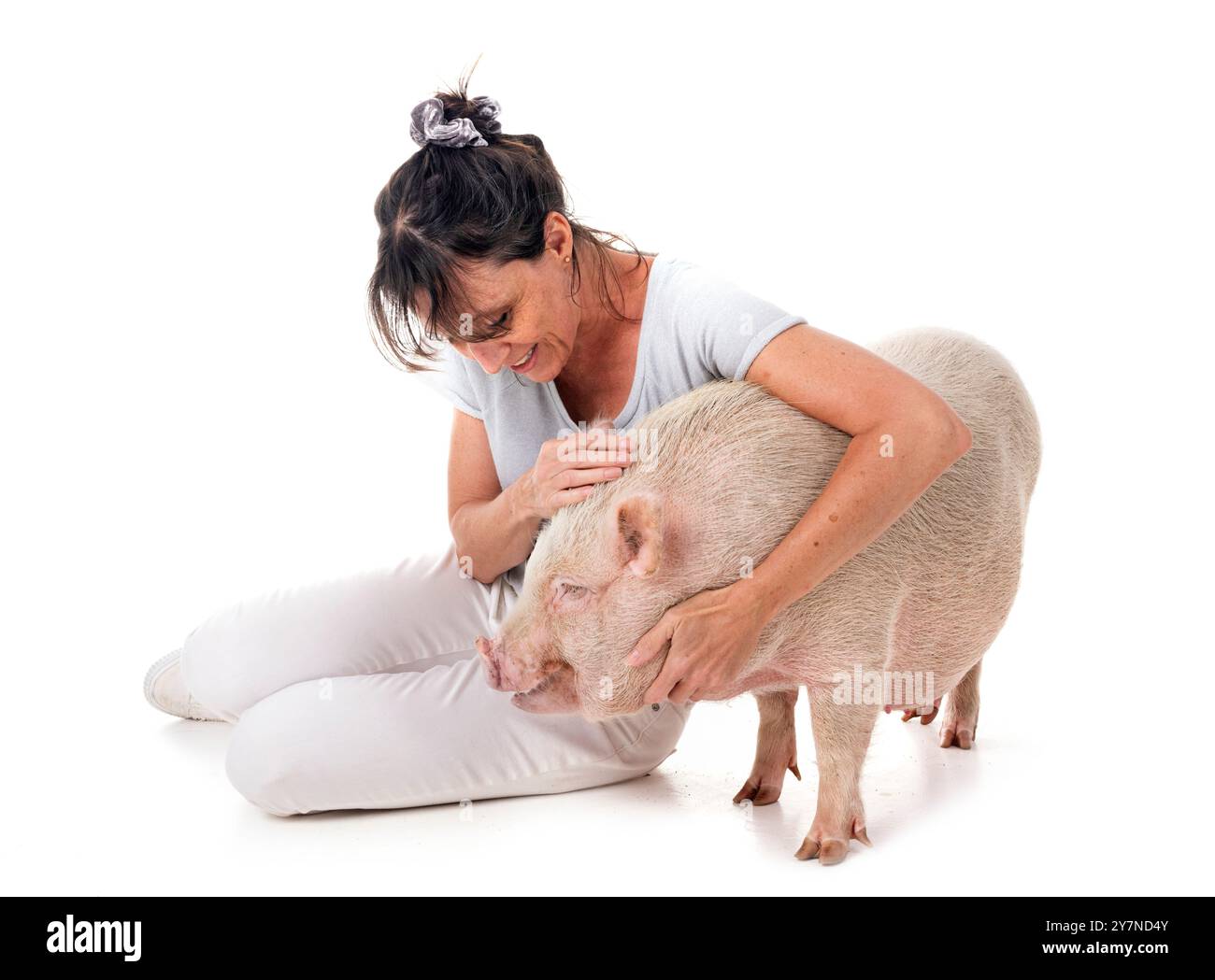 cochon miniature rose et femme devant fond blanc Banque D'Images