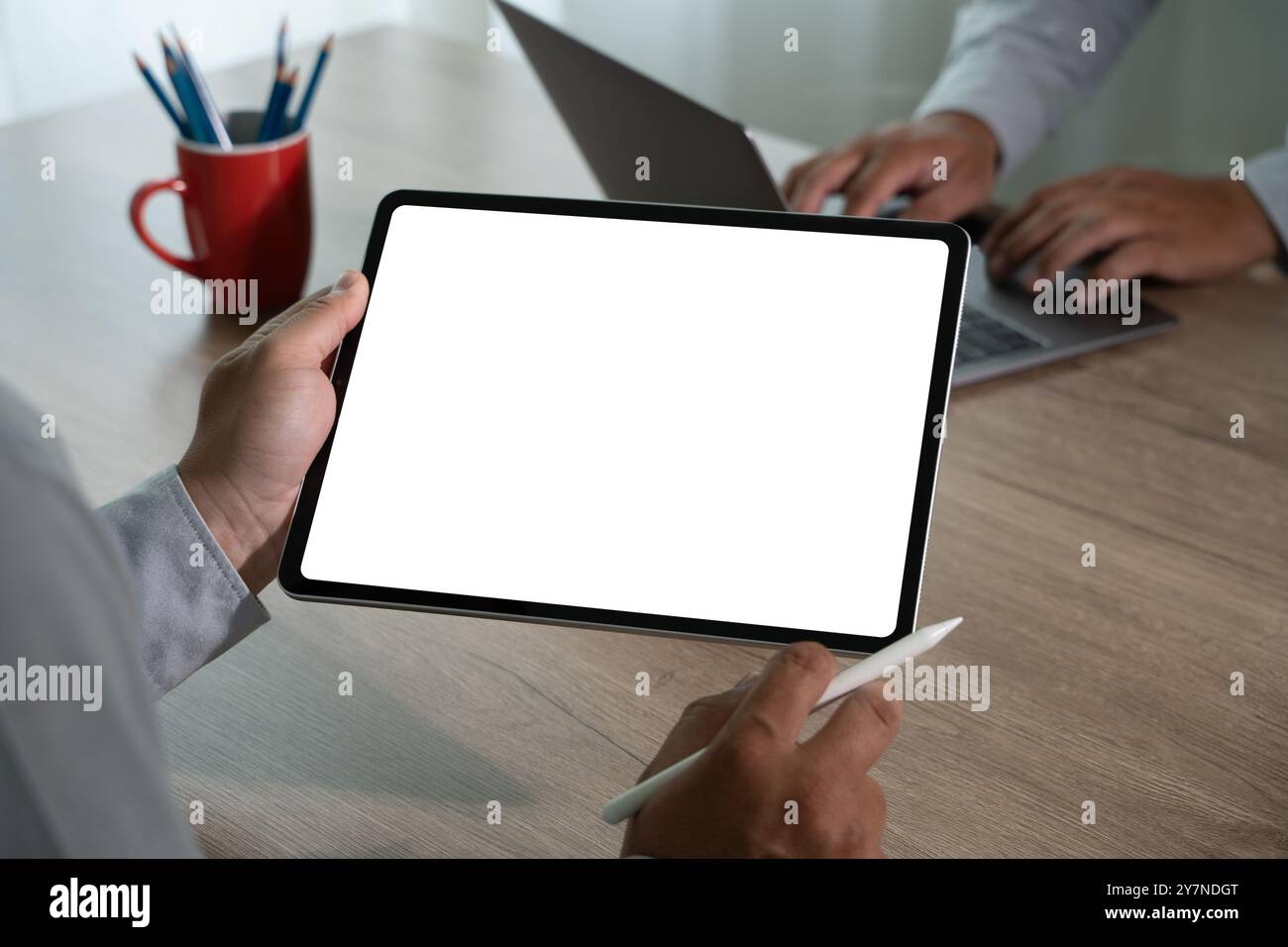homme d'affaires vérifiant sur la tablette numérique et tenant la tablette d'écran blanc dans le bureau Banque D'Images
