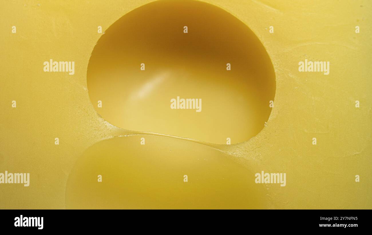 morceau de fromage gros plan , fromage jaune avec de grands trous , texture , macro photo Banque D'Images