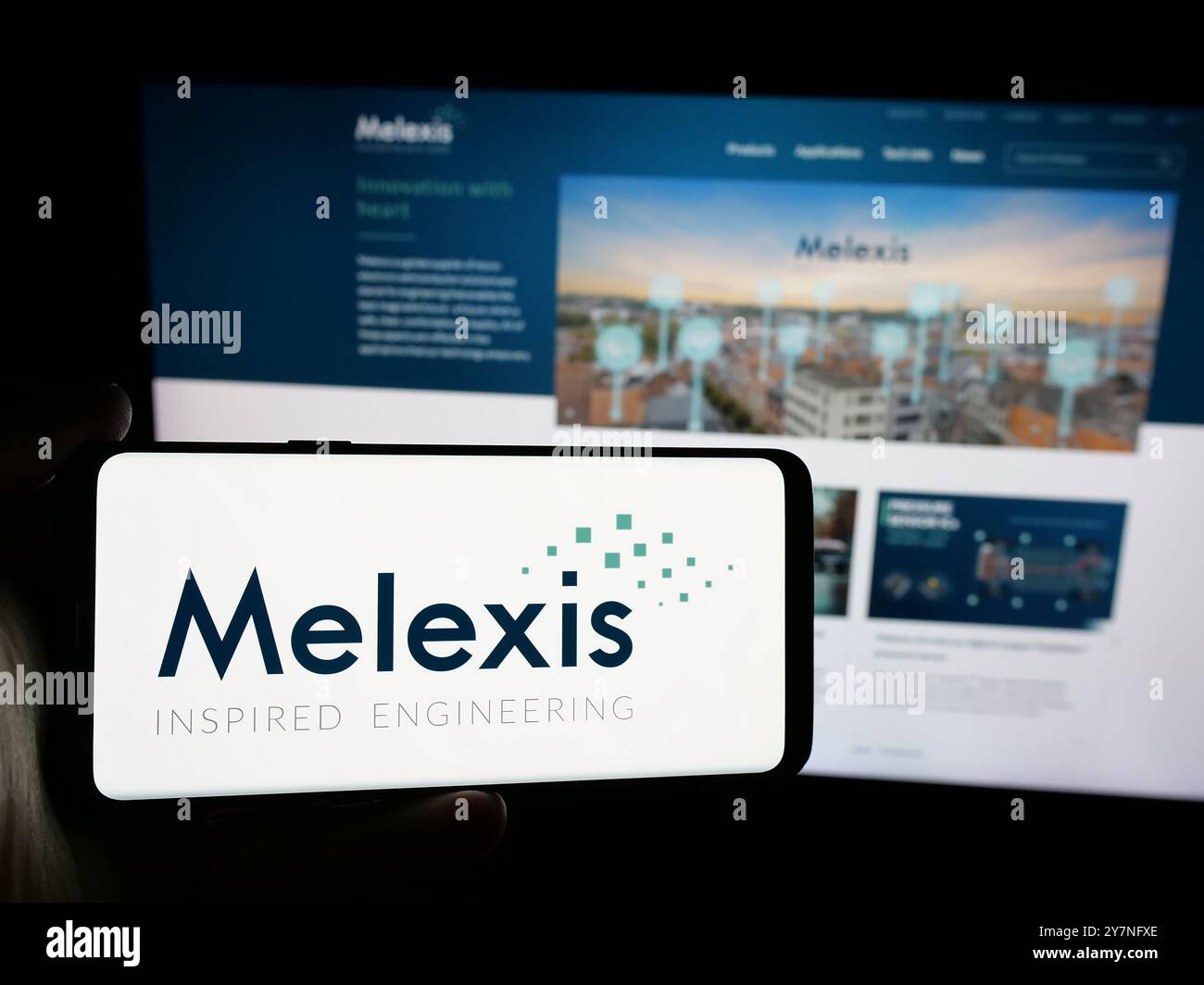 Personne tenant un smartphone avec le logo de la société belge de semi-conducteurs Melexis N.V. sur l'écran en face du site. Concentrez-vous sur l'affichage du téléphone. Banque D'Images