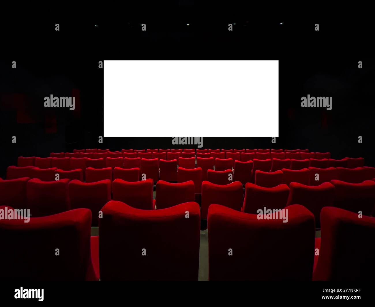 Cinéma avec écran de cinéma vierge et sièges rouges classiques Banque D'Images