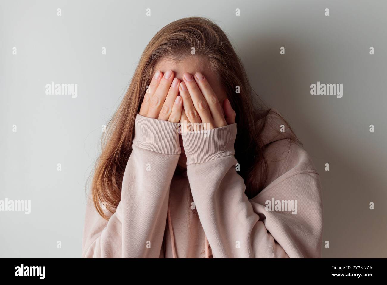 Gros plan jeune femme malheureuse se cachant le visage dans les mains, se sentant désespérée trompée sans espoir seule à l'intérieur. Fille millénaire bouleversée pleurant, souffrant de inconvénients Banque D'Images