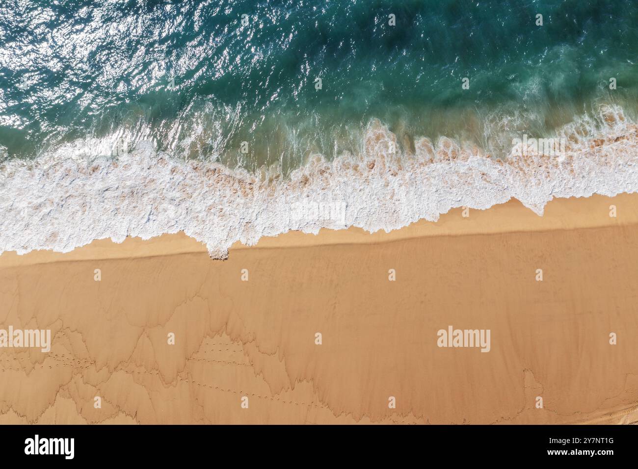 Eau de l'océan Azur et mousse de l'océan couvrant une belle longue plage de sable, vue aérienne drone. Beau fond de nature. Banque D'Images