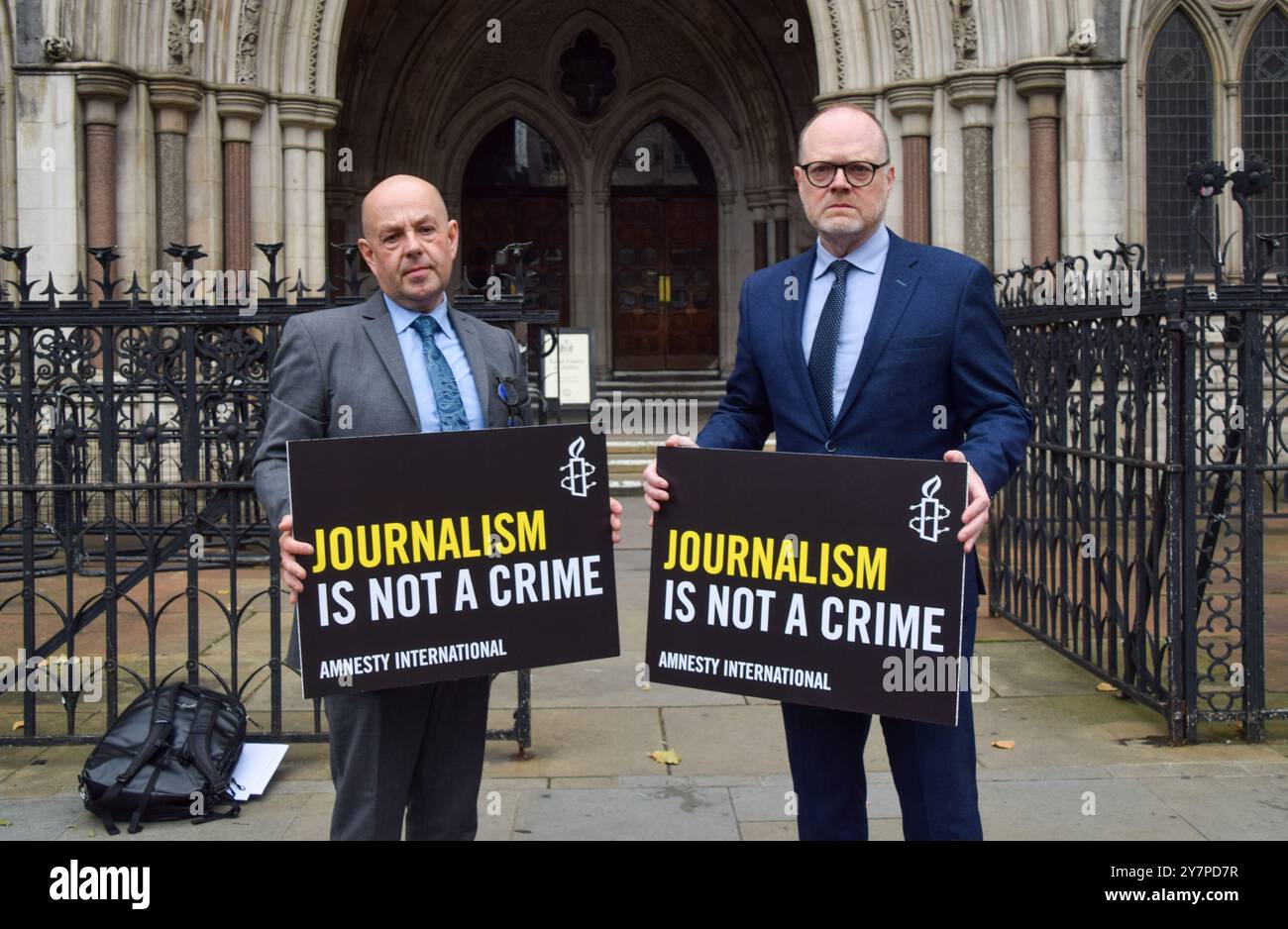 Londres, Royaume-Uni. 1er octobre 2024.. Les journalistes Barry McCaffrey et Trevor Birney tiennent des pancartes « le journalisme n'est pas un crime », alors que la surveillance policière des audiences du tribunal des journalistes commence à la Royal courts of Justice de Londres. Le couple aurait été espionné par la police, et les actions du Service de police d'Irlande du Nord, de la Durham Constabulary et de la met police de Londres seront examinées en fonction de leur rôle dans la surveillance illégale présumée. Crédit : Vuk Valcic/Alamy Live News Banque D'Images