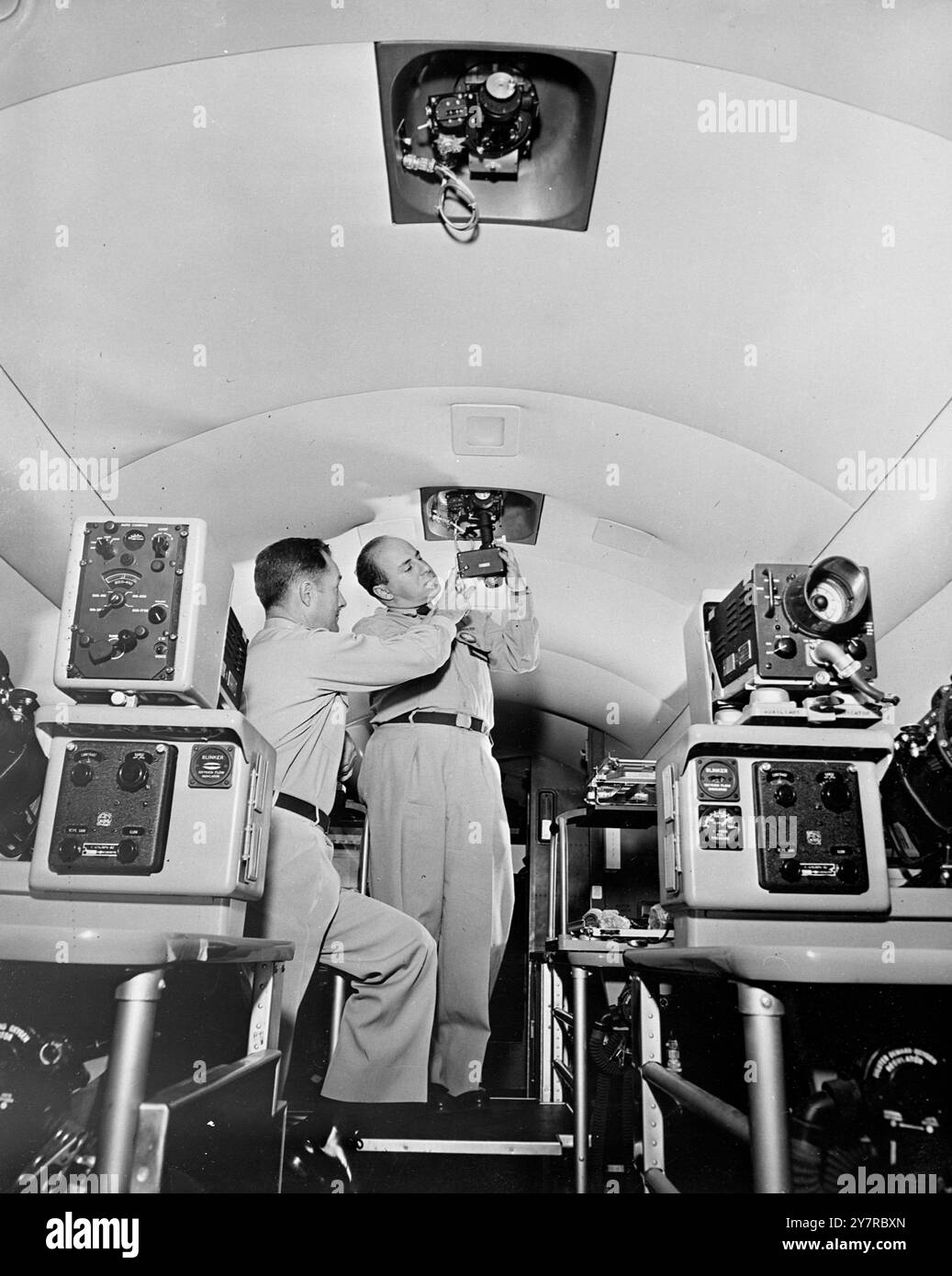 SALLE DE CLASSE DE VOL U.S.A.F. Le 18.2,54, les aviateurs étudiants de l'United States Air Force ont une nouvelle innovation à leur matériel didactique. C'est la salle de classe volante. Un Convair 7-29d a été modifié pour accueillir six élèves et deux instructeurs ainsi qu'un équipage et de l'équipement de vol. I.N.P. PHOTOS MONTRE : deux positions sextant sont fournies dans la section de la combinaison radar-navigation de la classe de pilotage. Des officiers de l'armée de l'air inspectent un sextant périscopique. 1.TDH. 74642 PHOTOS D'ACTUALITÉS INTERNATIONALES. Banque D'Images