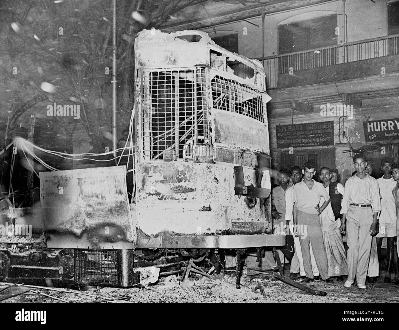 ÉMEUTES À CALCUTTA - SIX MORTS ET 70 BLESSÉS 20.2,54. Des troupes à casques d'acier portant des fusils ont aidé la police à maintenir l'ordre à Calcutta mercredi, après des émeutes au cours desquelles la police a ouvert le feu. Le nombre de morts était de six, avec 70 blessés. Dans le nord de Calcutta, la police a dispersé une foule de gens qui tentaient de creuser les voies de tramway. Les émeutes ont été déclenchées par la protestation de 1 000 enseignants qui ont bloqué une rue animée en manifestant pour plus de salaire. La photo de l'I.N.P. montre un train incendié qui a fait naufrage dans les émeutes de Calcutta mercredi. 41/MB/74675 nouvelles internationales photos. Banque D'Images