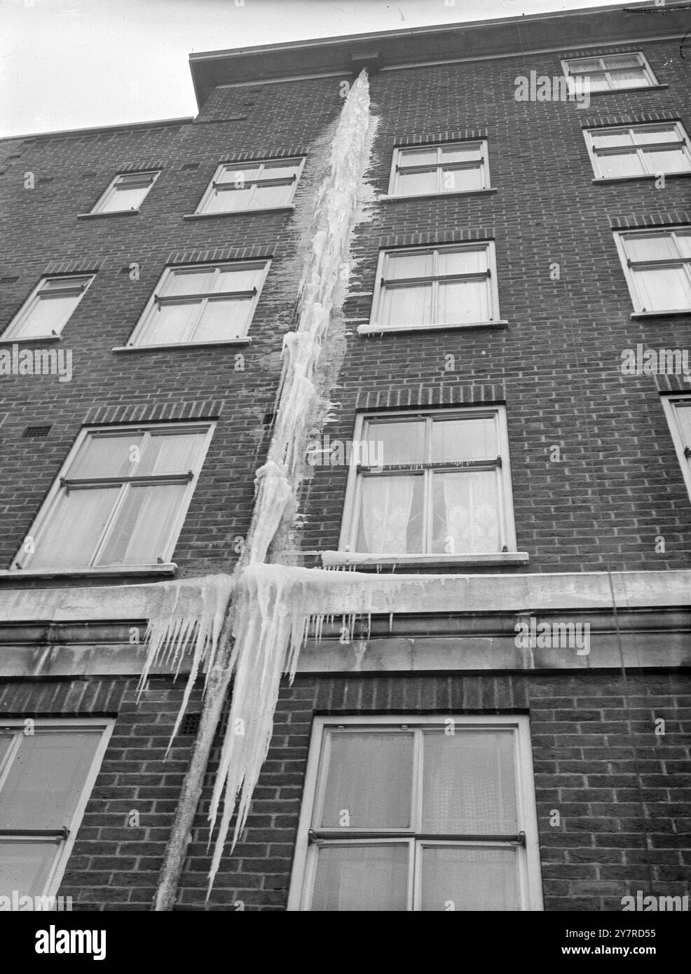 IL FAIT DE PLUS EN PLUS FROID. Et les glaçons deviennent de plus en plus gros. Dans le grand gel britannique. 2,2.54. Photo I.N.P. montre l'eau d'un tuyau de trop-plein fait ce glaçon géant à l'extérieur d'Effra court, un bloc d'appartements à Brixton Hill, Londres. Photo de R. Palmer. Photos d'actualités internationales. 74325 H. Banque D'Images