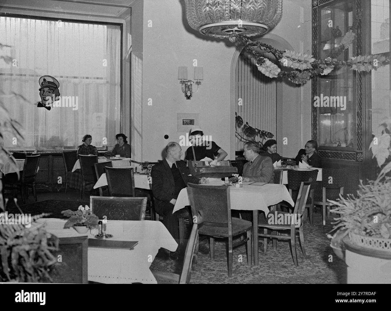 PHOTOGRAPHE INP. TOURS SECTEUR RUSSE DE BERLIN. Le photographe de l'INP a profité de la dispense spéciale soviétique pour voir l'autre côté du rideau de fer à Berlin-est pendant la conférence des Big four. I.N.P. photo montre une fille de cigarette de Berlin est servant un client dans le restaurant à la mode Warschau dans le secteur russe de Berlin. De tels lieux de restauration intelligents ne sont disponibles que pour les résidents de Berlin-est avec des revenus suffisamment élevés pour se permettre les prix élevés. Même ces endroits ont des annulations fréquentes dans le menu de certains cours qui ne peuvent plus être réparés à cause de la nourriture Banque D'Images