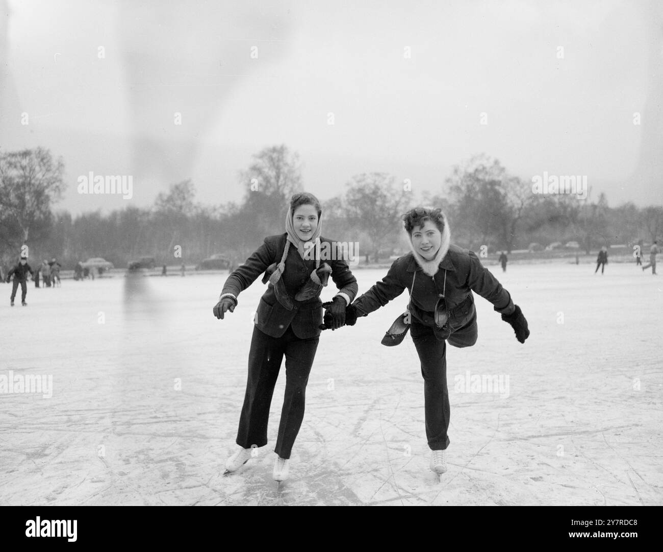 SPORTS D'HIVER À WIMBLEDON COMMUN. 31.1,54. I.N.P. photo montre que les amateurs de sports d'hiver ont vraiment réussi à le faire aujourd'hui sur le Wimbledon Common de Londres. Ici, deux aspirants de patinage ont attaché leurs chaussures de marche normales autour de leur cou pour leurs bottes de patinage. Photo de J. Davies. 74293/gd. Photo(s) d'actualités internationales. Banque D'Images