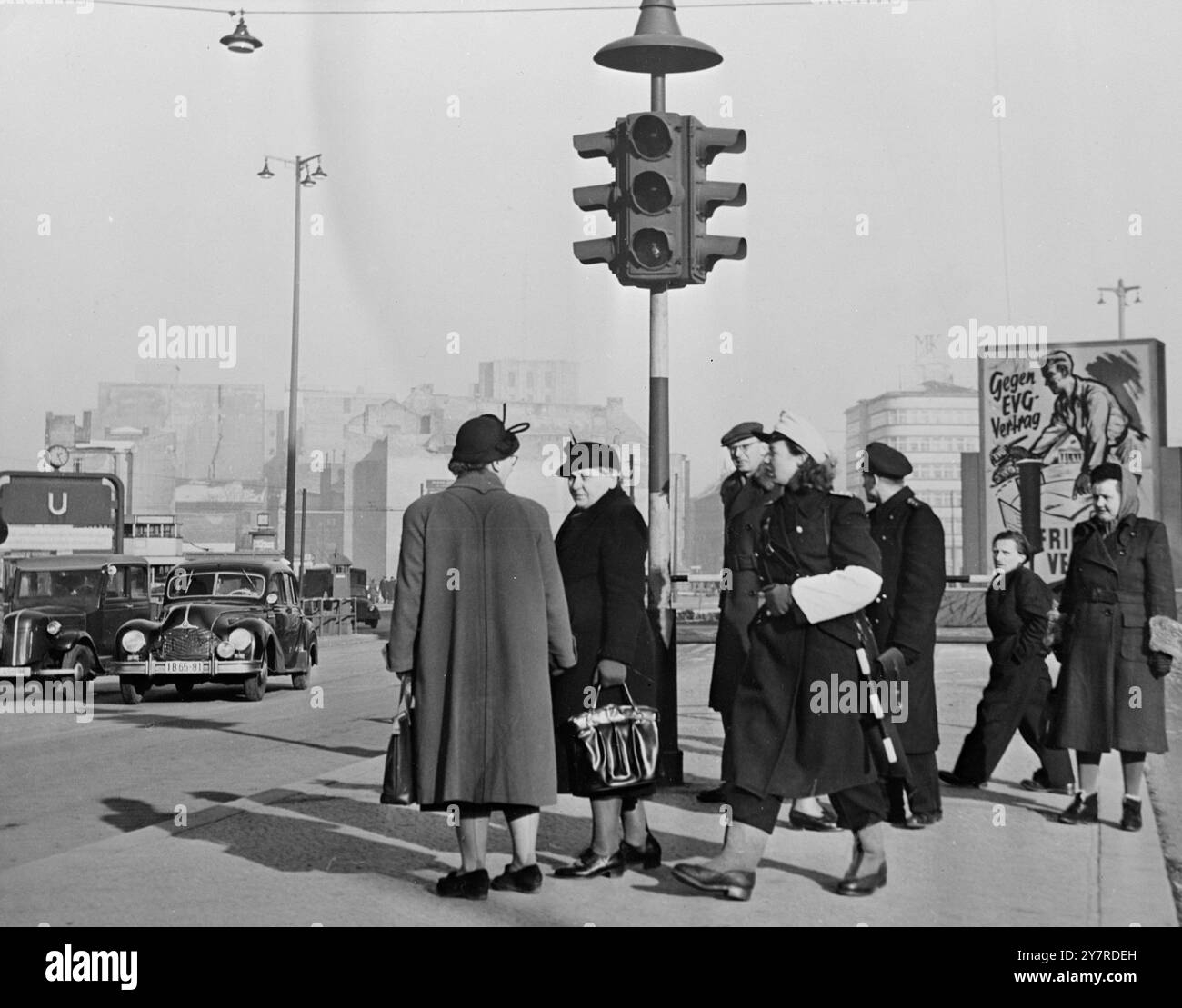PHOTOS DANS LE SECTEUR EST DE BERLIN. 28.1,54. Le photographe I.N.P. visite le secteur est de Berlin avec l'autorisation accordée par les autorités soviétiques pour la durée de la conférence. Photo I.N.P. montre une dame flic de la circulation en charge de Alexanderplatz, Berlin est, balançant son bâton de contrôle de la circulation. Une affiche à l'arrière-plan montre un travailleur derrière le siège soviétique à la réunion des Big four poussant des chars hors de la table : la légende est "10 contre le traité de la CED, pour le traité de paix". EW 74230. Photos d'actualités internationales. Banque D'Images