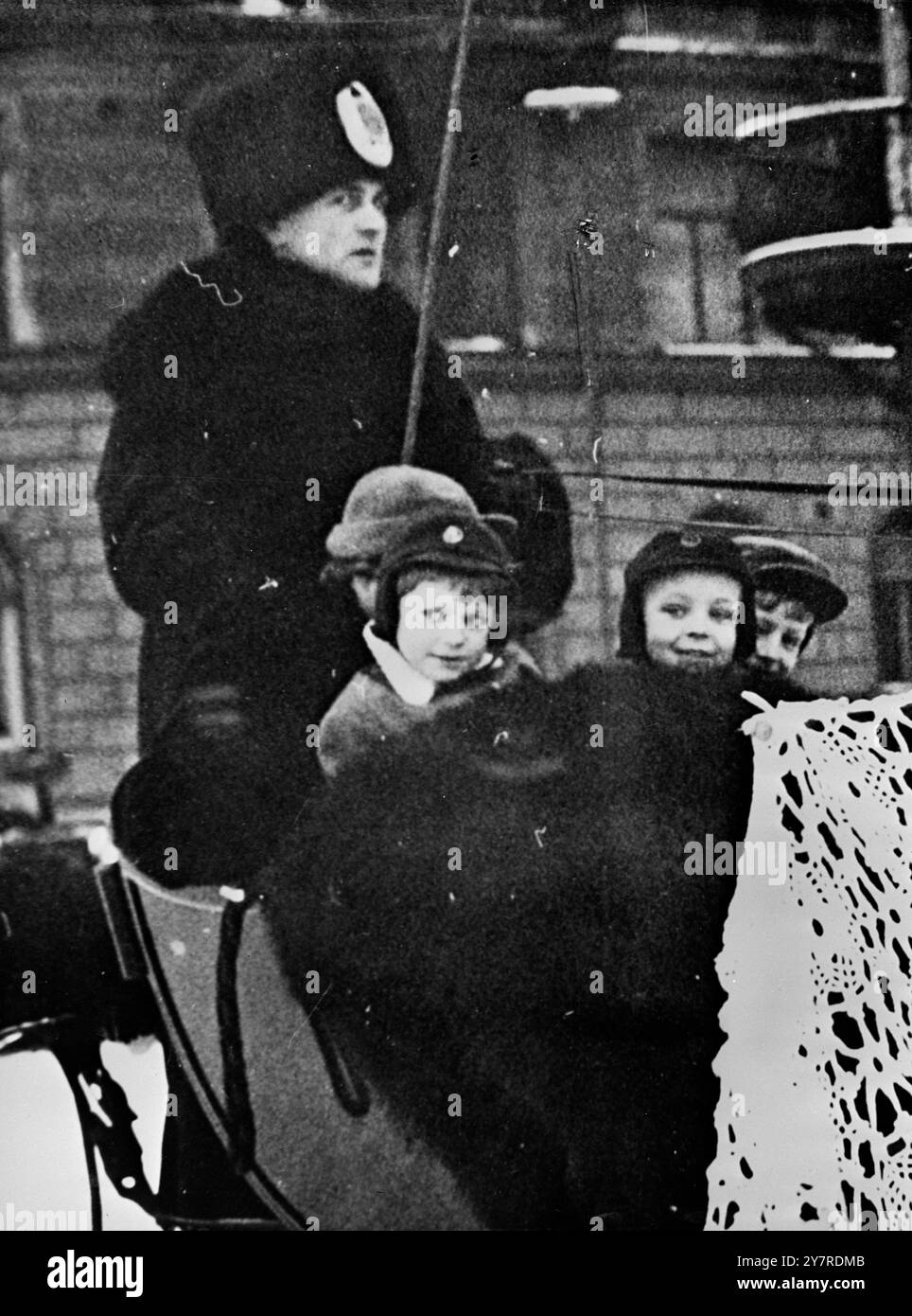 ROYAL SLEDGE DRIVE. 27.I.54. Le petit prince héritier suédois Carl Gustaf s'est occupé du beau temps hivernal pour une promenade en luge dans le parc de 'Djurgården' Stockholm, hier. Ici, il est vu à droite avec son infirmière et ses camarades de jeu, à côté de lui se trouve le jeune Carl-Johan Smith. 532.EM. 74190. International News photos. Banque D'Images