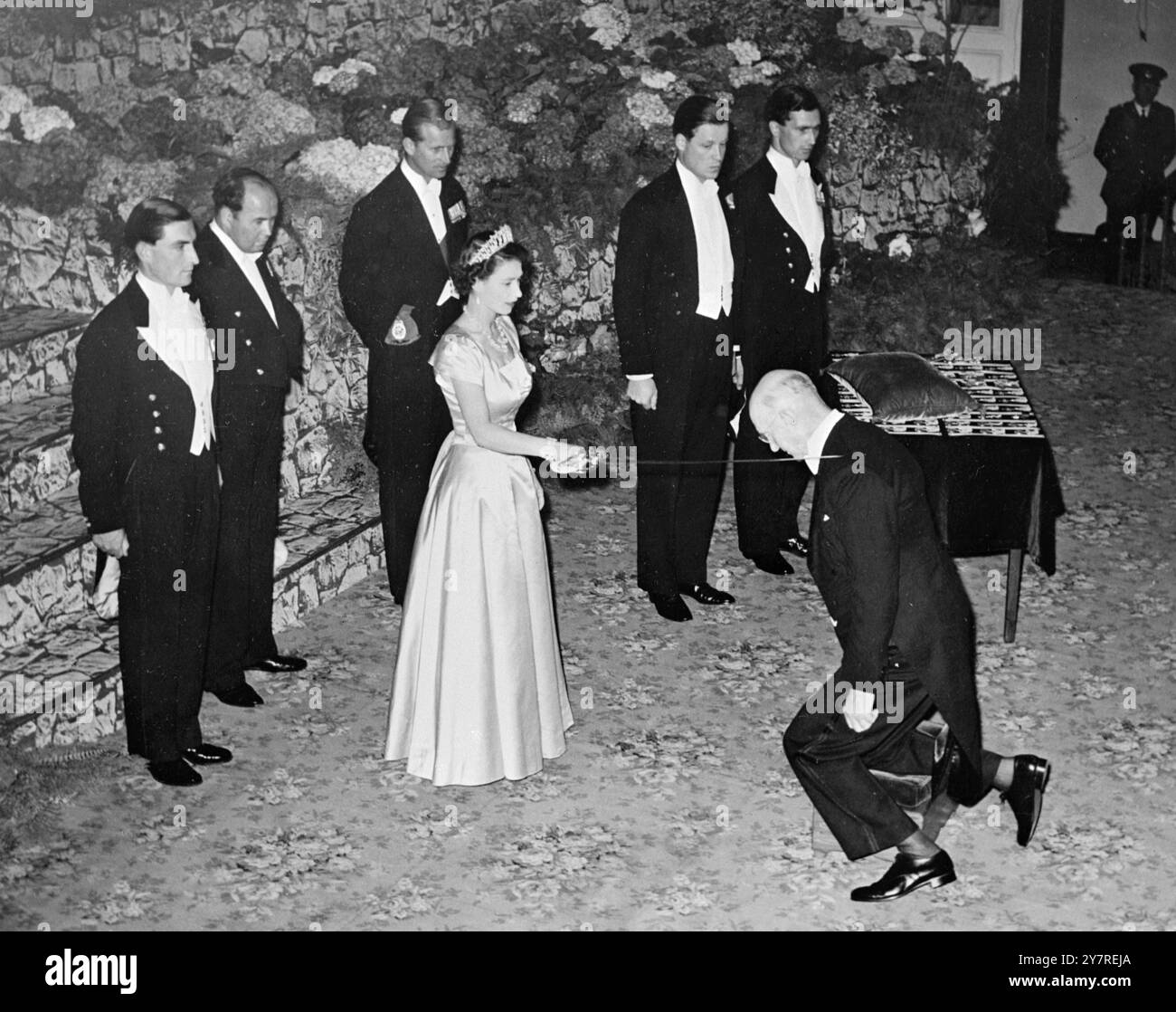 VISITE ROYALE. 5,1.54. EXPOSITIONS DE PHOTOS DE l'I.N.P. : la Reine a tenu une investiture à l'hôtel de ville d'Auckland. Il y a eu quelque 60 récipiendaires de prix, et de nombreux membres des forces armées néo-zélandaises ont été décorés pour leur service en Corée. Cette photo montre sa Majesté doublant Sir William Goodfellow de la manière traditionnelle. Pool/Timez /gd@73558. Photos d'actualités internationales. Banque D'Images