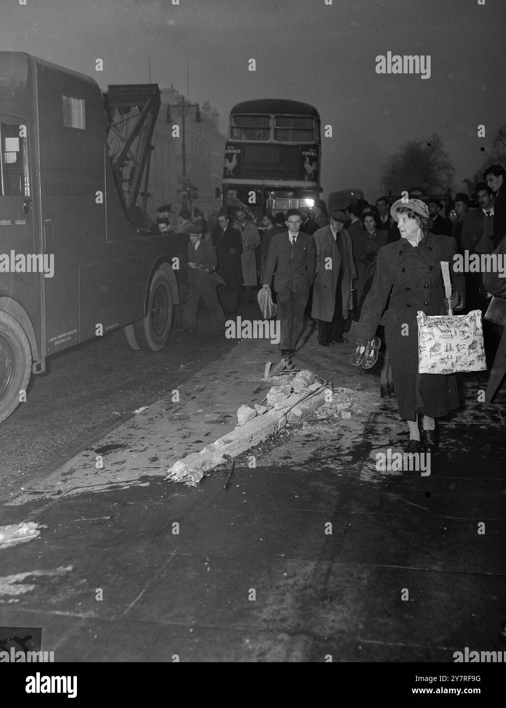 Un bus londonien s'écrase à Hyde Park Corner. 17.12.53. Deux hommes auraient été tués et 19 personnes blessées lorsqu'un autobus 96 se rendant à Putney s'est écrasé cet après-midi dans un abri de bus à Hyde Park Corner. L'accident a eu lieu à l'extérieur de l'hôpital George, où le conducteur, M. F. W. Cook, et le chef d'orchestre, son épouse, M. V. E. Cook, ont été traités pour choc. L'abri d'autobus et une partie d'un mur ont été démolis. La photo INP montre des acheteurs marchant devant des morceaux de l'abri de bus démoli à Hyde Park Corner. Photo de Joe Waldorf. PJ/73363. Photos d'actualités internationales. Banque D'Images