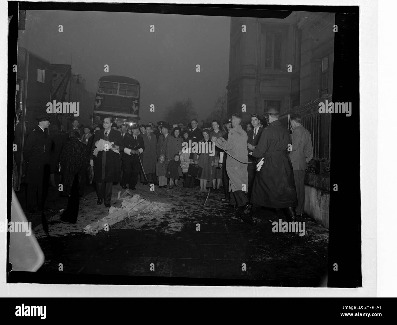 Un bus londonien s'écrase à Hyde Park Corner le 17.12.53. Deux hommes auraient été tués et 19 autres blessés lorsqu'un bus E96 se rendant à Putney s'est écrasé dans un abri de bus à Hyde Park Corner cet après-midi. L'accident a eu lieu à l'extérieur de l'hôpital George, où le conducteur, M. F. W. Cook, et le chef d'orchestre, son épouse, M. V. E. Cook, ont été traités pour choc. L'abri d'autobus et une partie d'un mur ont été démolis. La photo de l'INP montre des fonctionnaires prenant des mesures sur les lieux de l'accident. Photo de Joe Waldorf. PJ/73364. Photos d'actualités internationales. Banque D'Images