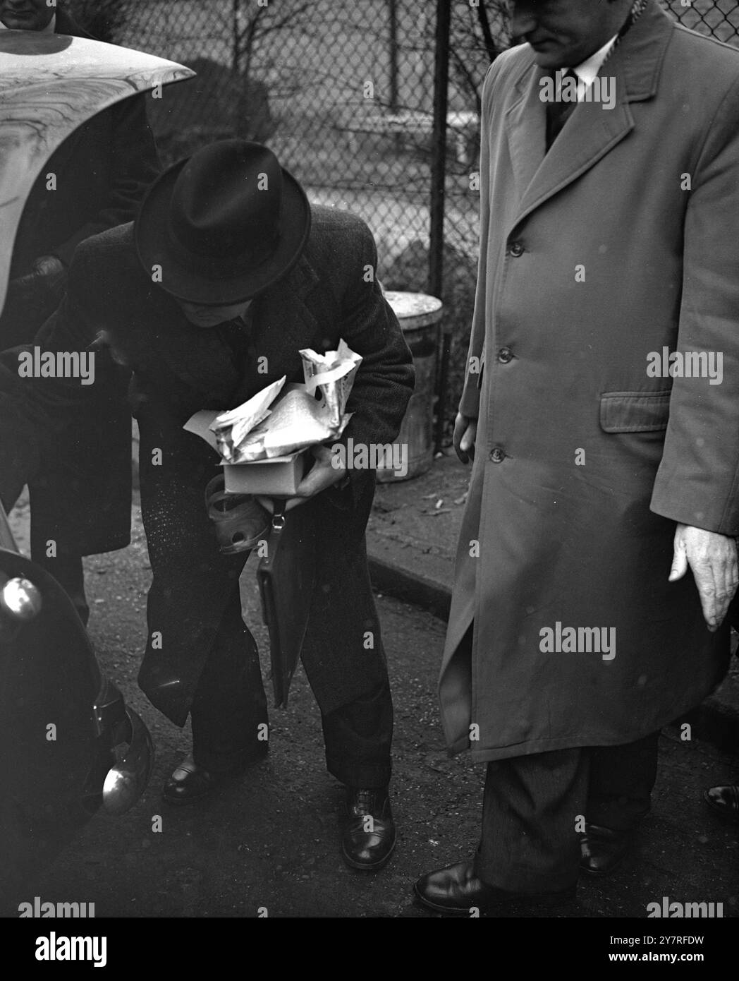 Meurtre à Wembley. 16.12.53. Beatrice Elizabeth James, 42 ans, a été poignardée, étranglée et battue à mort hier après-midi dans son logement de second Avenue, Wembley. Scotland Yard a publié une description d'un homme qu'ils souhaitent interviewer. On pense que ses vêtements peuvent être fortement tachés de sang et ses mains lacérées. La photo INP montre Det. Insp. Casey réalisant des expositions, dont les chaussures de la femme assassinée. Photo de J. Waldorf. EM 73323. Photos d'actualités internationales. Banque D'Images