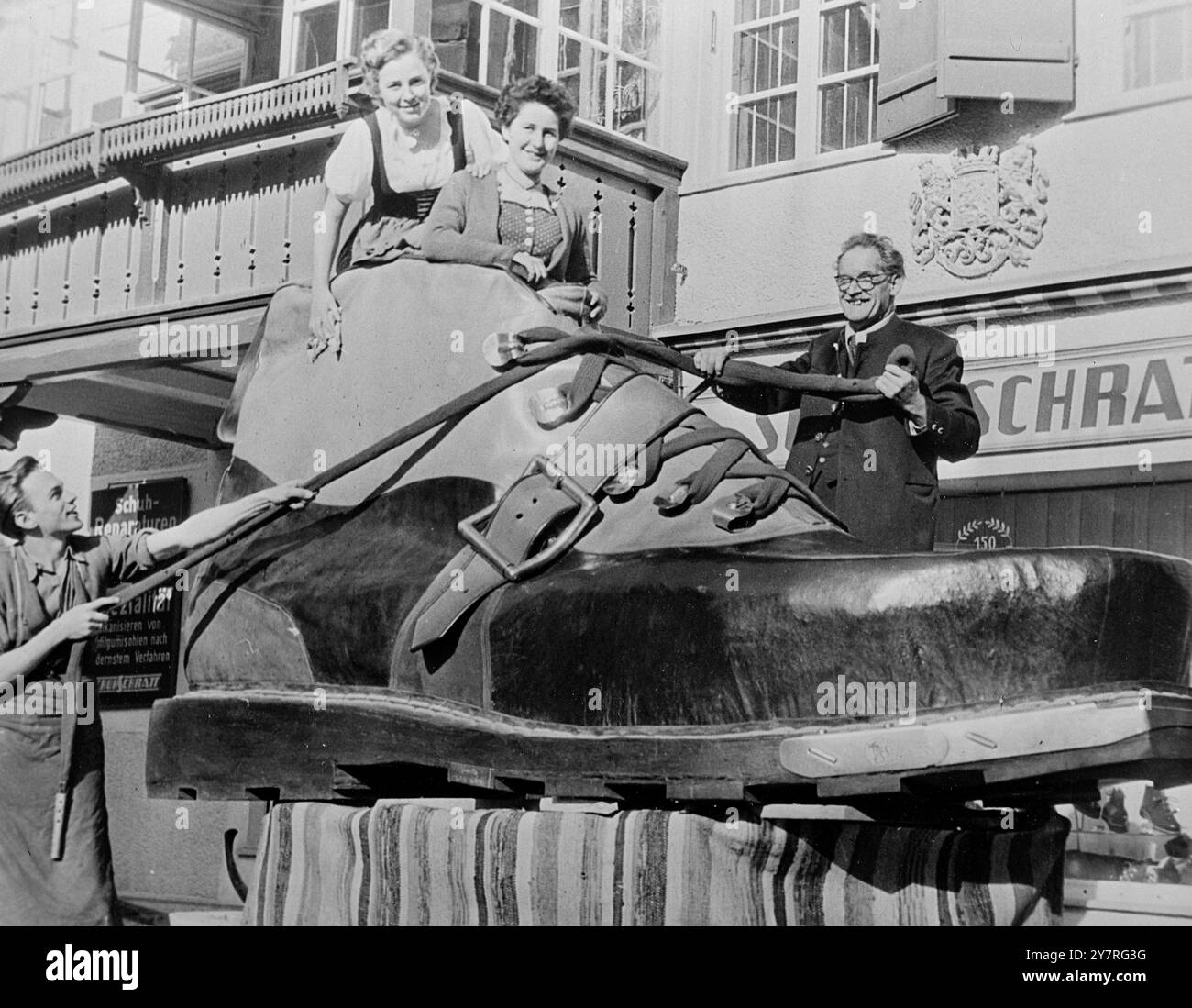 Chaussure de ski pour géant. 2.12.53. Neuf vaches, un morceau de peau d'éléphant et 65 mètres de corde d'alpinisme ont été mis au point pour fabriquer cette chaussure de ski géante. Josef Schratt, 67 ans, le lacant (à droite) avec un assistant, a fait en sorte qu'il soit exposé dans une exposition. Il a dû fabriquer la botte à l'extérieur de son atelier à Oberstdorf, en Bavière. 133/PJ/73012. Photos d'actualités internationales. Banque D'Images