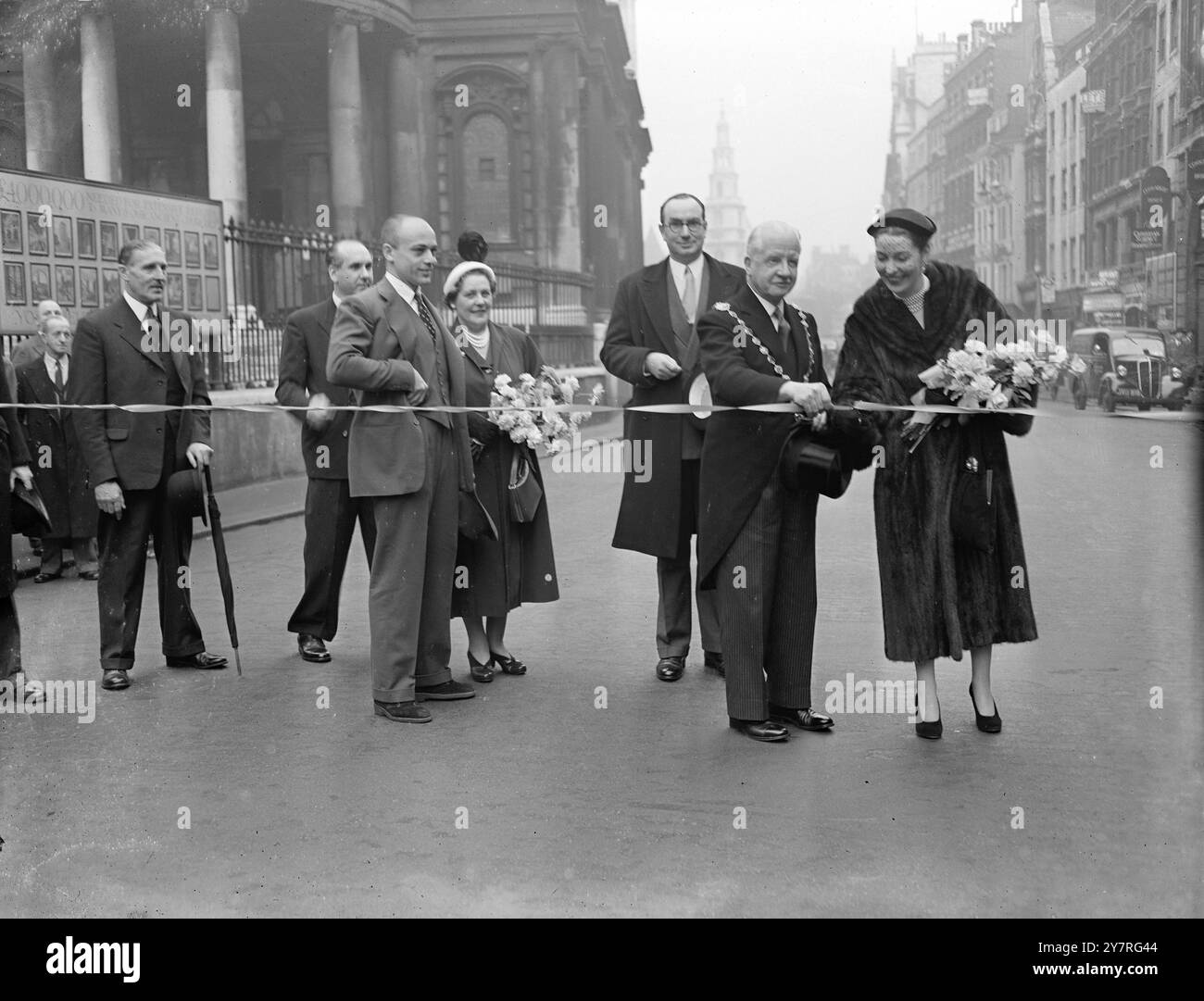 Réouverture du Strand 2.12.53 les semaines de shopping de Noël Strand ont été inaugurées ce matin lors d’une cérémonie à l’église de Mary-le-Strand où le maire de Westminster a coupé une bande tendue de l’autre côté de la route. Valerie Hobson et Herbert Lom, les stars de la production londonienne de The King and I, ont ensuite roulé le long du Strand dans une Wolseley de 1900. La photo INP montre le maire de Westminster coupant le ruban pour ouvrir le Strand et ses semaines de shopping de Noël. Photo de Jack Davies PJ/73018 International News photos. Banque D'Images