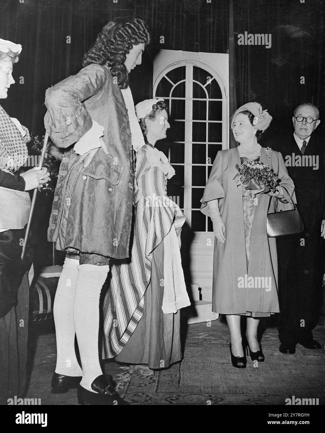 Intermède royal à R.A.D.A. 12.11.53 la Reine Elizabeth la Reine mère a rendu hier soir visite à la Royal Academy of Dramatic Art où elle a rencontré des étudiants en formation pour des carrières sur scène. La photo de l'INP montre la Reine mère s'arrêtant pour discuter avec James Villiers de Colchester et Juliet Callaway jouant dans une pièce de théâtre d'époque. FO/RT/PA/72519 nouvelles internationales photos. Banque D'Images