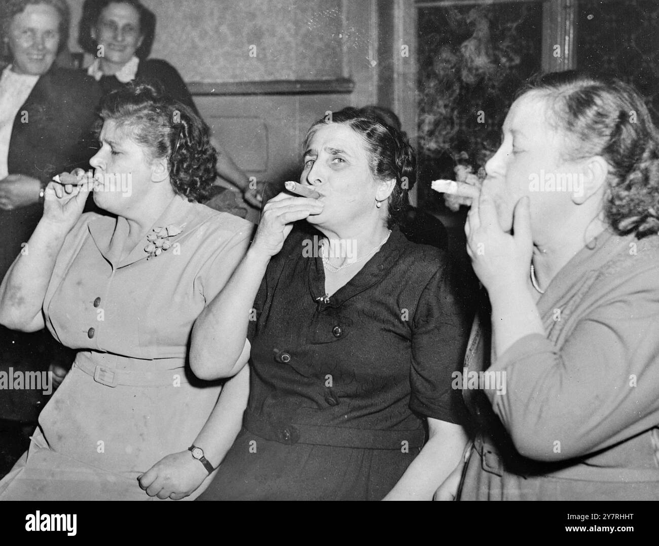 Bouffant pour le titre 29.10.53. Les femmes fumeuses de cigares du Dortmund 'nicotine' Smoking Club et du Essen 'Keep on Smoking' Club se sont rencontrées cette semaine dans une compétition pour décider qui est la championne de la femme fumeuse. Ils ne savent toujours pas, car les concurrents ont soufflé tellement de fumée que les juges ne pouvaient pas voir assez pour arriver à une décision. I.N.P. photo montre trois des concurrentes dame gonflant à leurs cigares dans une offre pour le titre. 133/PJ/72215 nouvelles internationales photos. Banque D'Images