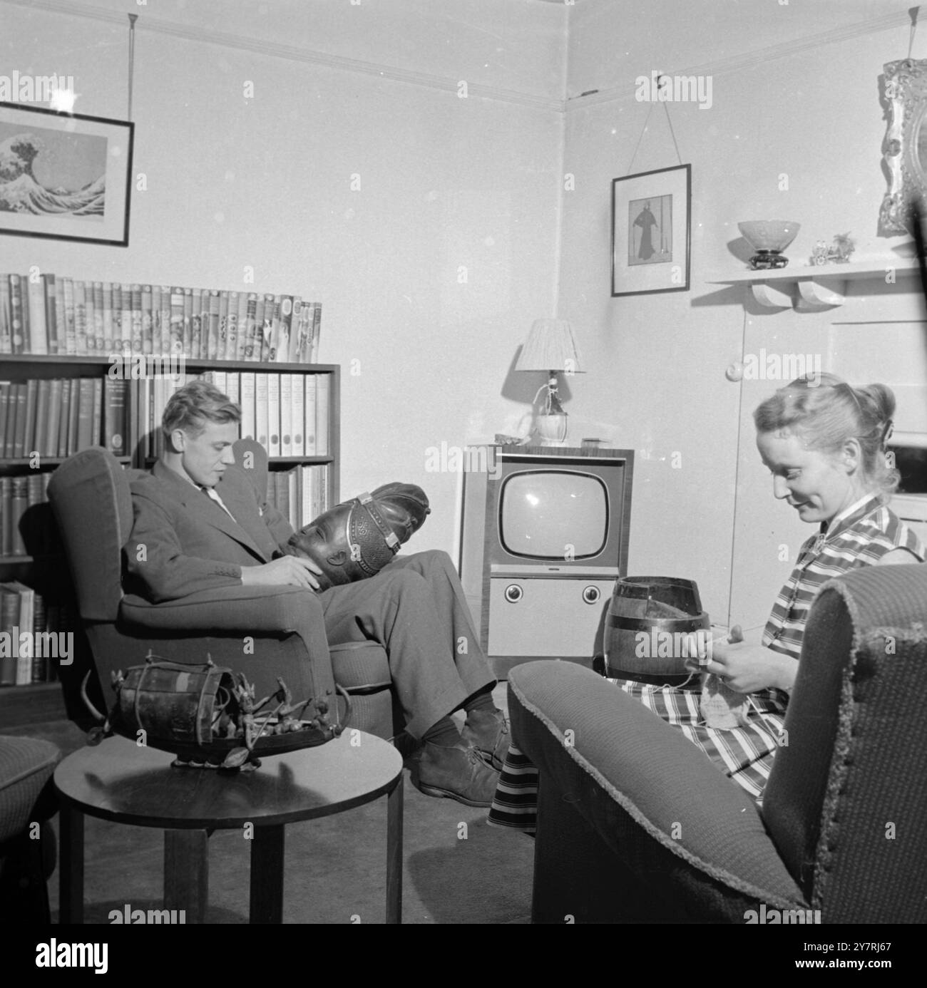 DAVID ATTENBOROUGH CHEZ LUI À RICHMOND photographies de George Douglas Jane Knits et David examine un trophée à côté du petit écran, bientôt illuminé de ses aventures. 24 septembre 1955 Banque D'Images DAVID ATTENBOROUGH CHEZ LUI À RICHMOND photographies de George Douglas Jane Knits et David examine un trophée à côté du petit écran, bientôt illuminé de ses aventures. 24 septembre 1955 Banque D'Images