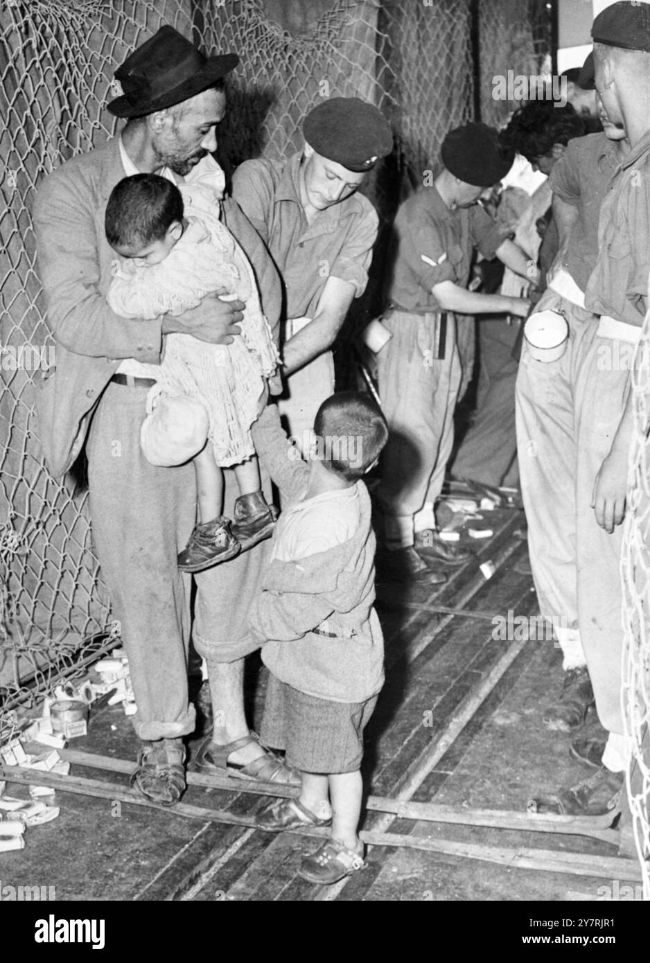 LES TROUPES BRITANNIQUES RECHERCHENT DES IMMIGRANTS ILLÉGAUX ALORS QUE LES DERNIERS NAVIRES ATTEIGNENT HAÏFA 29 JUILLET 1947. Les deux derniers navires immigrés "retour à Sion" et "quatorze victimes de l'Asib" sont arrivés hier à Haïfa quand ils ont été embarqués par l'armée et la marine britanniques. Il ne fait aucun doute que, du fait que les Juifs étaient transbordés vers Chypre et non pas vers les pays d'embarquement, il n'y a pas eu d'incidents violents. INP PHOTO MONTRE : les troupes recherchent un immigrant transportant un jeune enfant du 'retour à Sion' à Haïfa hier. Banque D'Images