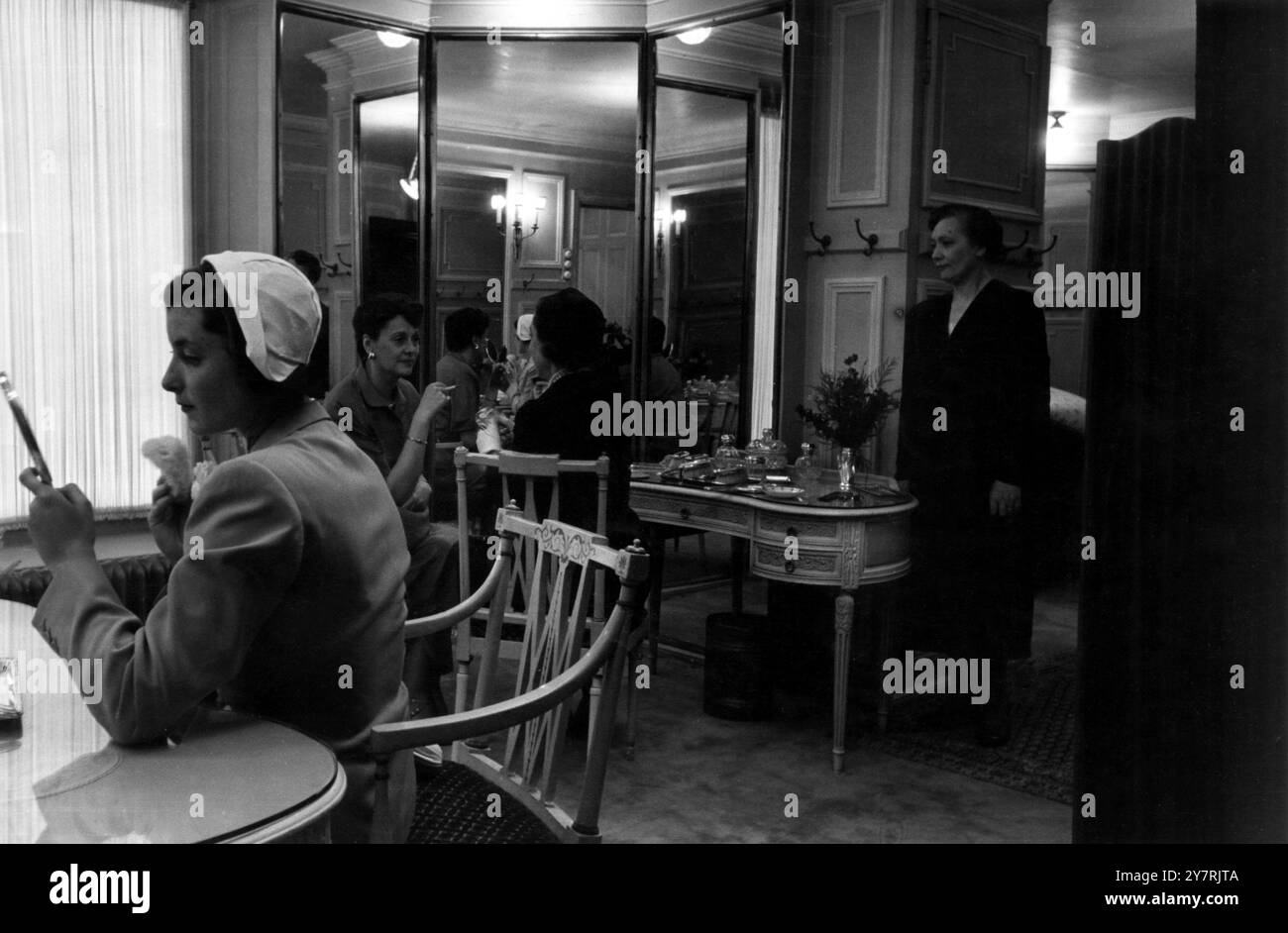 LE RITZ HOTELLondon Angleterre : tous les jours, 200 000 personnes passent devant le Ritz Hotel à Piccadilly. Moins de la moitié pour cent passent par ses portes élégantes. Quelle vie de grandeur flunkeyed y est tenue ? Cette série d'images montre une journée dans cet hôtel de luxe avec son personnel attentionné et ses salles de réception grandioses. Spectacles de photos : la salle de poudre pour dames du Ritz est naturellement pleine de miroirs. En arrière-plan, on peut voir Miss Irene Worth the actrice et l'honorable Mrs Sherek, sœur du comte de Falmouth. Le salon de coiffure pour dames était à l'étage. 7 octobre 1950 Banque D'Images
