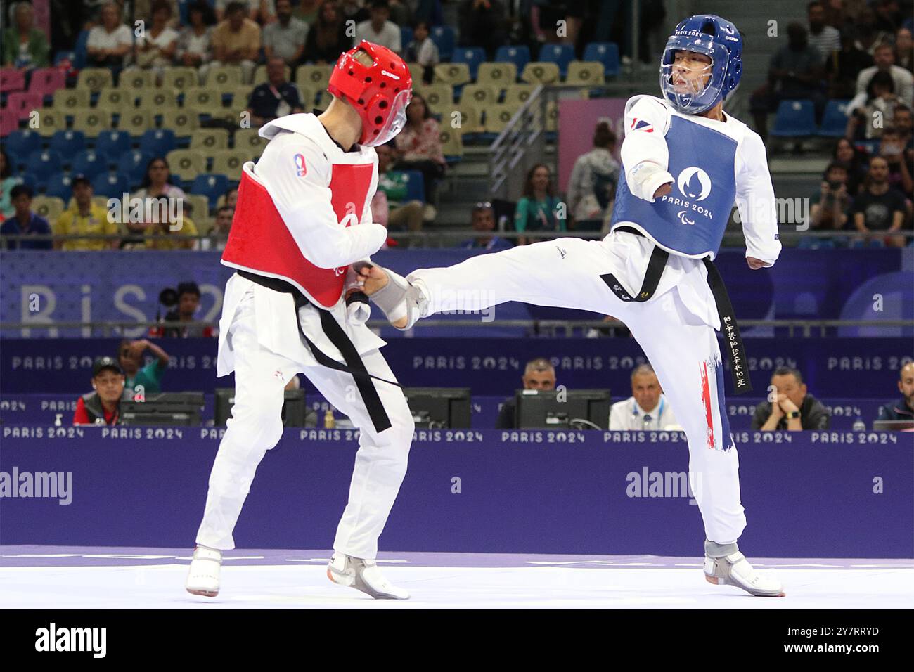 Thanwa KAENKHAM de Thaïlande (bleu) vs Bopha KONG de France (rouge) au concours para Taekwondo - hommes K44 -58kg de repêchage au Grand Palais, Paris, aux Jeux paralympiques de 2024. Banque D'Images