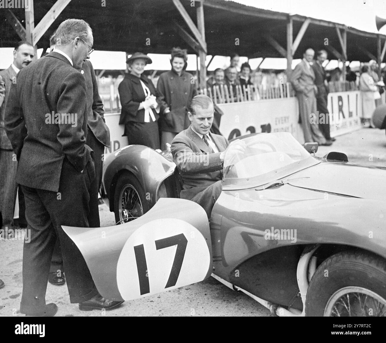 DUKE AVEC DES AUTOMOBILISTES DE COURSE À GOODWOOD. 30.8.53 le duc d'Édimbourg, qui séjourne à Goodwood House pour la semaine de course, a visité ce matin le circuit automobile de Goodwood pour inspecter certaines des voitures britanniques qui, par leurs succès dans la course de 24 heures au Mans et sur d'autres circuits continentaux, ont tellement contribué au prestige de l'industrie automobile britannique. Le duc, accompagné du duc de Richmond et Gordon, a parlé aux directeurs des sociétés Jaguar, Aston Martin Austin-Healey, Bristol, Fraser Nash et Allard sur les développements techniques et a regardé les voitures rouler Banque D'Images