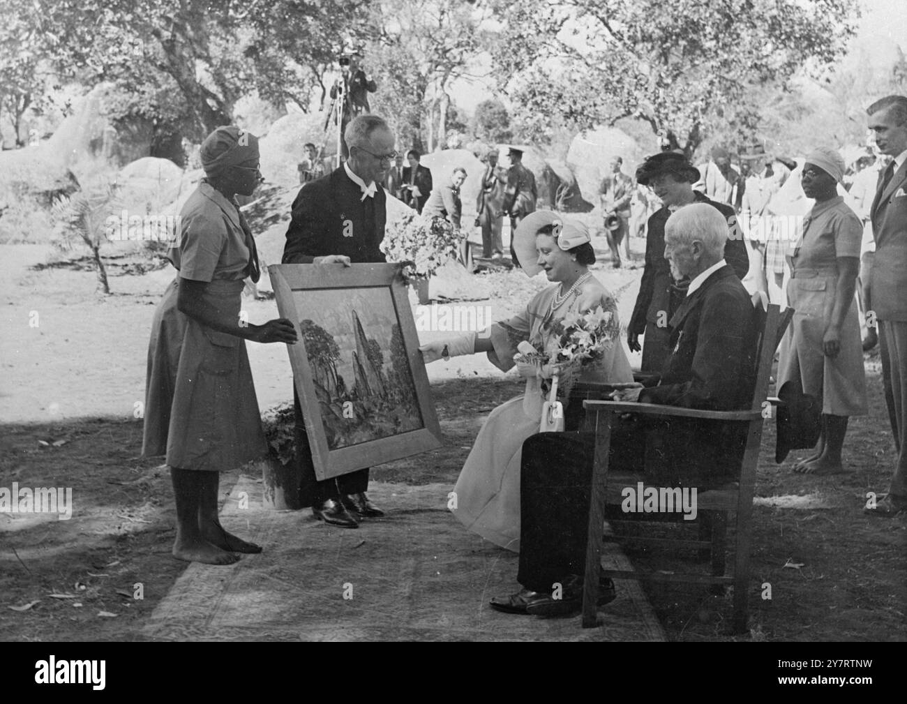 LA REINE MÈRE REÇOIT DES CADEAUX À LA MISSION MORGENSTER (légende originale)expositions de photos - à la mission Morgenster, près de Fort Victoria, Rhodésie, sa Majesté la reine Elizabeth, la reine mère, est photographiée alors qu'elle reçoit d'autres cadeaux pour gonfler les dizaines déjà reçues. 14 juillet 1953 Banque D'Images