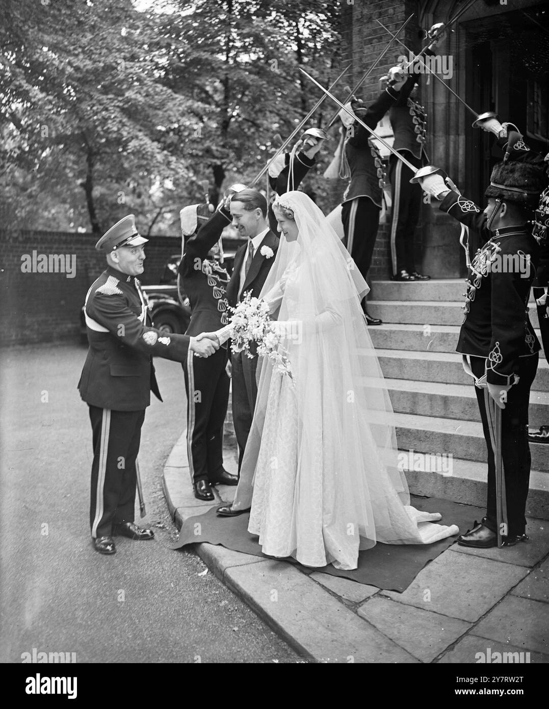 FÉLICITATIONS DE LA R.S.M. 6,7.53. Le mariage a eu lieu à l'église Holy Trinity, Brompton Road, cet après-midi, du capitaine W. F. P. Currie, des Hussars de la Reine, et de Mlle A. K. Hamilton-Russell. La photo montre le sergent-major régimentaire William Thomas, qui commandait la Garde d'honneur des Hussars de la Reine, félicite la mariée après la cérémonie. 6 juillet 1953 Banque D'Images