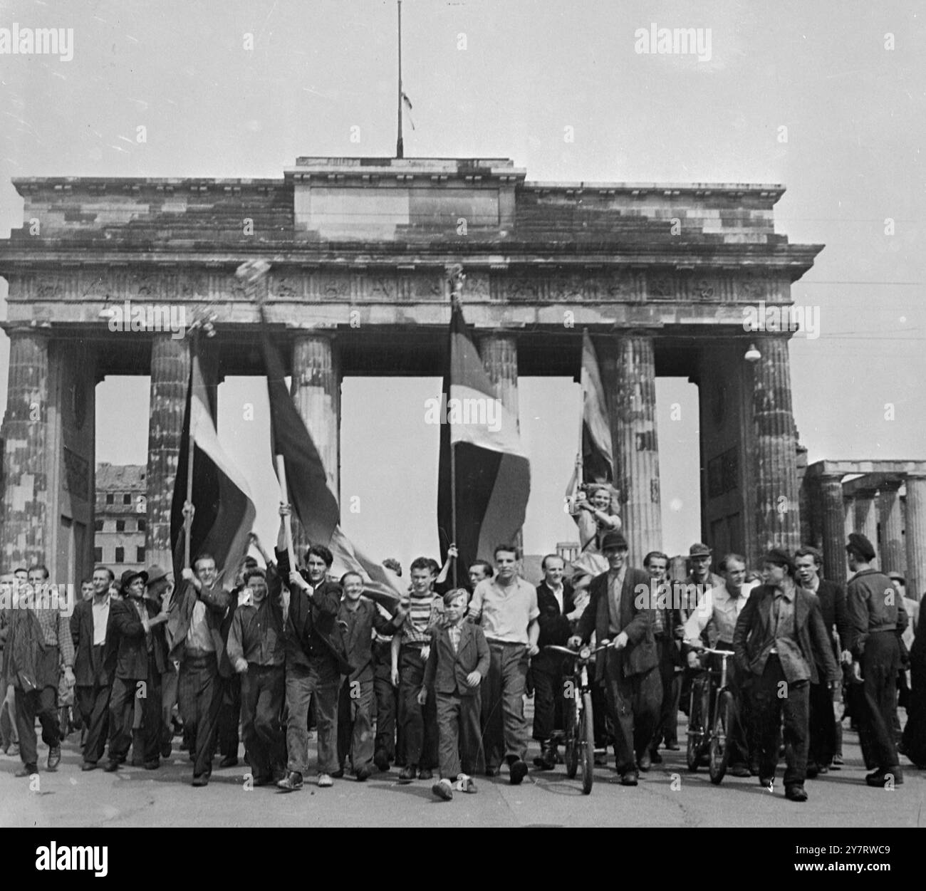 DRAPEAU OUEST-ALLEMAND PORTÉ À BERLIN-EST 18.6.53 la loi martiale a été déclarée hier à Berlin-est à la suite d'émeutes généralisées contre l'administration soviétique. La photo montre des manifestants marchant dans la zone russe de Berlin portant le drapeau noir, rouge et or de l'Allemagne de l'Ouest après avoir démoli et brûlé le drapeau rouge sur la porte de Brandebourg. 18 juin 1953 Banque D'Images