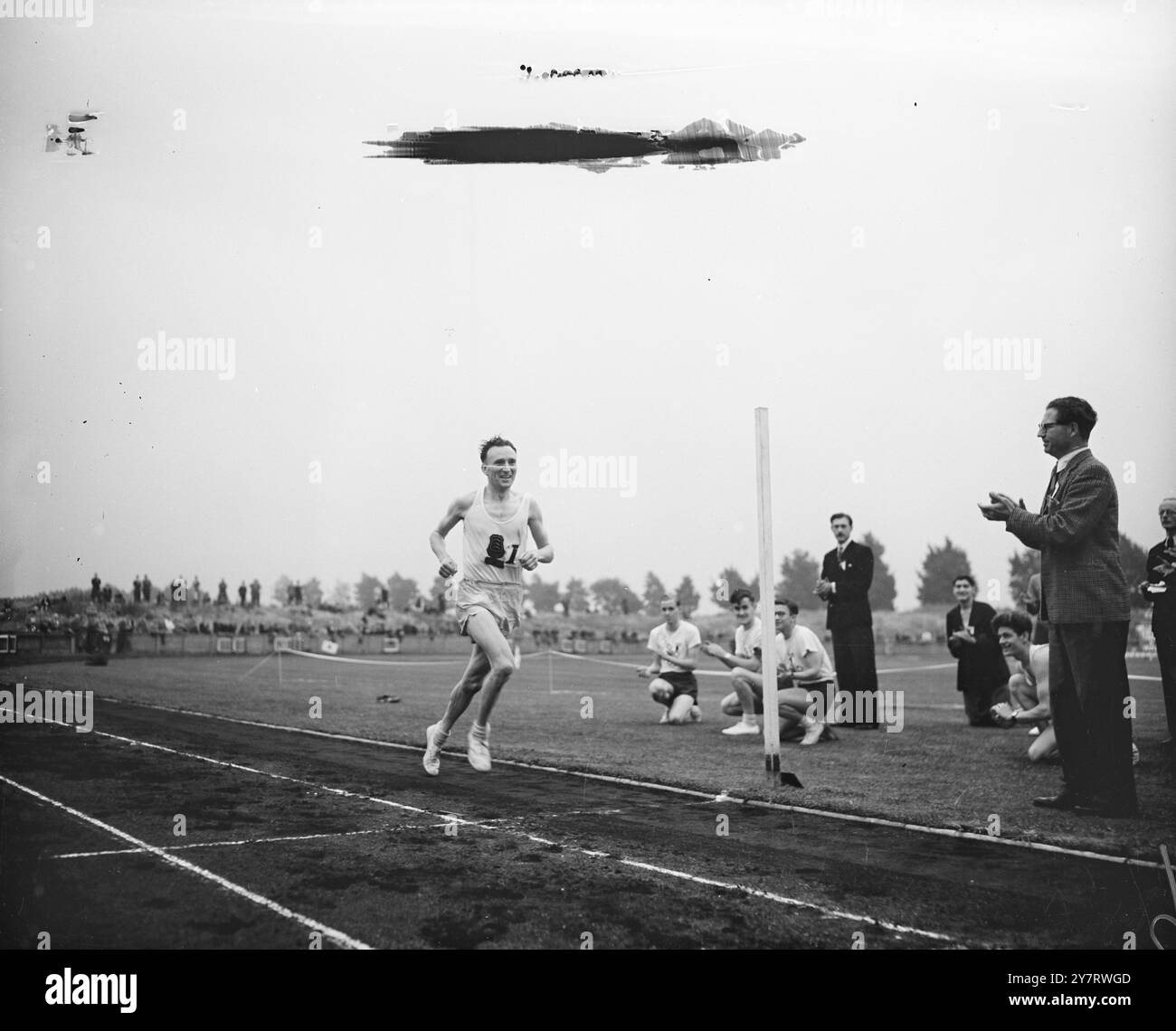 JIM PETERS REMPORTE LE TROPHÉE KINNAIRD TROPHÉE DES STARS DE LA PISTE À LA RÉUNION DU TROPHÉE KINNAIRD. 13.6,53. Des records devraient être battus dans plusieurs épreuves lors de la rencontre sportive du Trophée Kinnaird à Chiswick cet après-midi. L'arrivée du marathon Polytechnique de Windsor a été le point culminant de la réunion. PHOTOS. Jim Peters photographié alors qu'il gagnait la course du marathon cet après-midi, il est vu souriant alors qu'il casse la bande, il court la distance en 2h 18 min, pour battre le record et remporter le trophée Kinnaird. 13 juin 1953 Banque D'Images