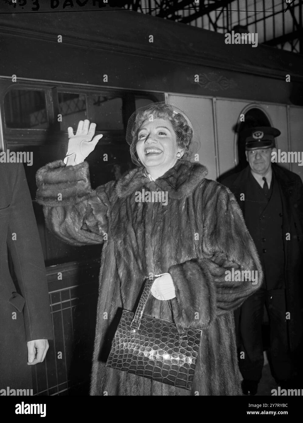 CLAUDETTE COLBERT ARRIVE ICI POUR FAIRE UN FILM BRITANNIQUE DE LA FEMME DES PLANTEURS BRITANNIQUES EN MALAISIE...4,3.52. PHOTOS : CLAUDETTE COLBERT, star de cinéma américaine, est arrivée aujourd'hui à Waterloo Station dans le train Queen Mary Boat. Elle est ici pour jouer dans le film britannique Made de la vie de la femme du planteur britannique en Malaisie. On la voit ici agiter à son arrivée à Waterloo. 4 mars 1952 Banque D'Images