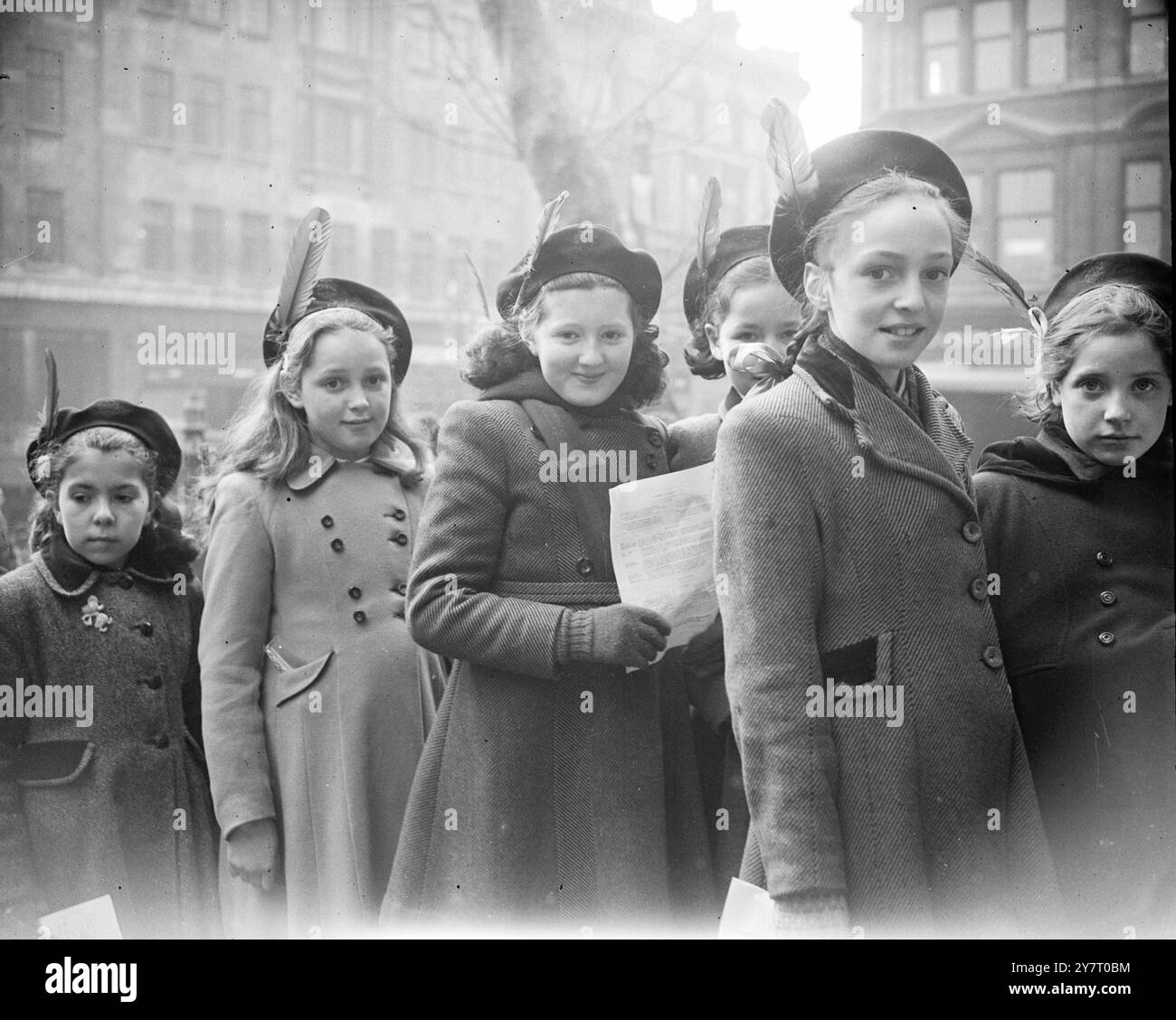 JOUR DE LA PLUME ROUGE POUR Une ÉCOLE LONDONIENNE 20-2-52 aujourd'hui était le jour de la plume rouge pour les enfants de l'école Sir John Cass, le jour où ils célèbrent le 291e anniversaire de la naissance de leur fondateur, dont la plume s'est tachée de sang alors qu'il mourait en réprimant son testament. I.N.P. PHOTOS MONTRE :- enfants de l'école Sir John Cass, portant des plumes rouges en mémoire de leur fondateur, arrivant pour le service annuel à l'église Botolph, Aldgate, Londres, aujourd'hui. Photo de J. Davies. PHOTOS D'ACTUALITÉS INTERNATIONALES. D/59943 Banque D'Images