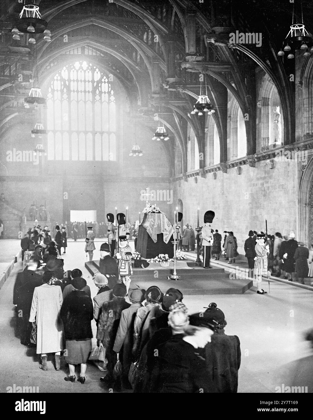 LA SCÈNE IMPRESSIONNANTE ALORS QUE LA MULTITUDE FILE DEVANT LE SOUVERAIN. 13-2-52 I.N.P. PHOTO SHOWS:- image historique dans le Grand Hall de Westminster aujourd'hui, des gardes silencieux veillent sur la catafalque du roi George VL alors que le flux lent et sans fin de gens file passé en hommage révérent à leur défunt roi. Des milliers et des milliers de personnes, de tous horizons, ont attendu pendant des heures dans la longue file d'attente devant le hall. La file d'attente s'étire maintenant sur des kilomètres. Il fait six, huit et parfois dix profondeurs, il va de Westminster jusqu'au pont Lambeth, de l'autre côté de la rivière pour revenir à Westminster Brid Banque D'Images