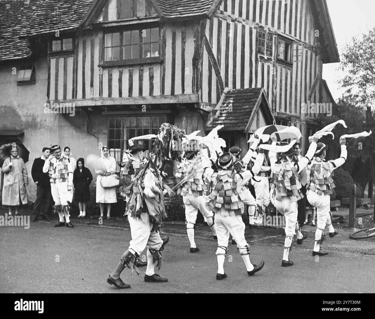 MORRIS DANCERS À EYNSFORDThe Beaux of London City - un groupe de Morris Dancers, a joué dans le village d'Eynsford samedi soir dernier, Kent, Angleterre, Royaume-Uni. La pluie fortuitement a cessé de jouer peu après qu'ils ont commencé - mais il y avait une excellente auberge à portée de main où tous ont été accueillis. 8 mai 1961 Banque D'Images
