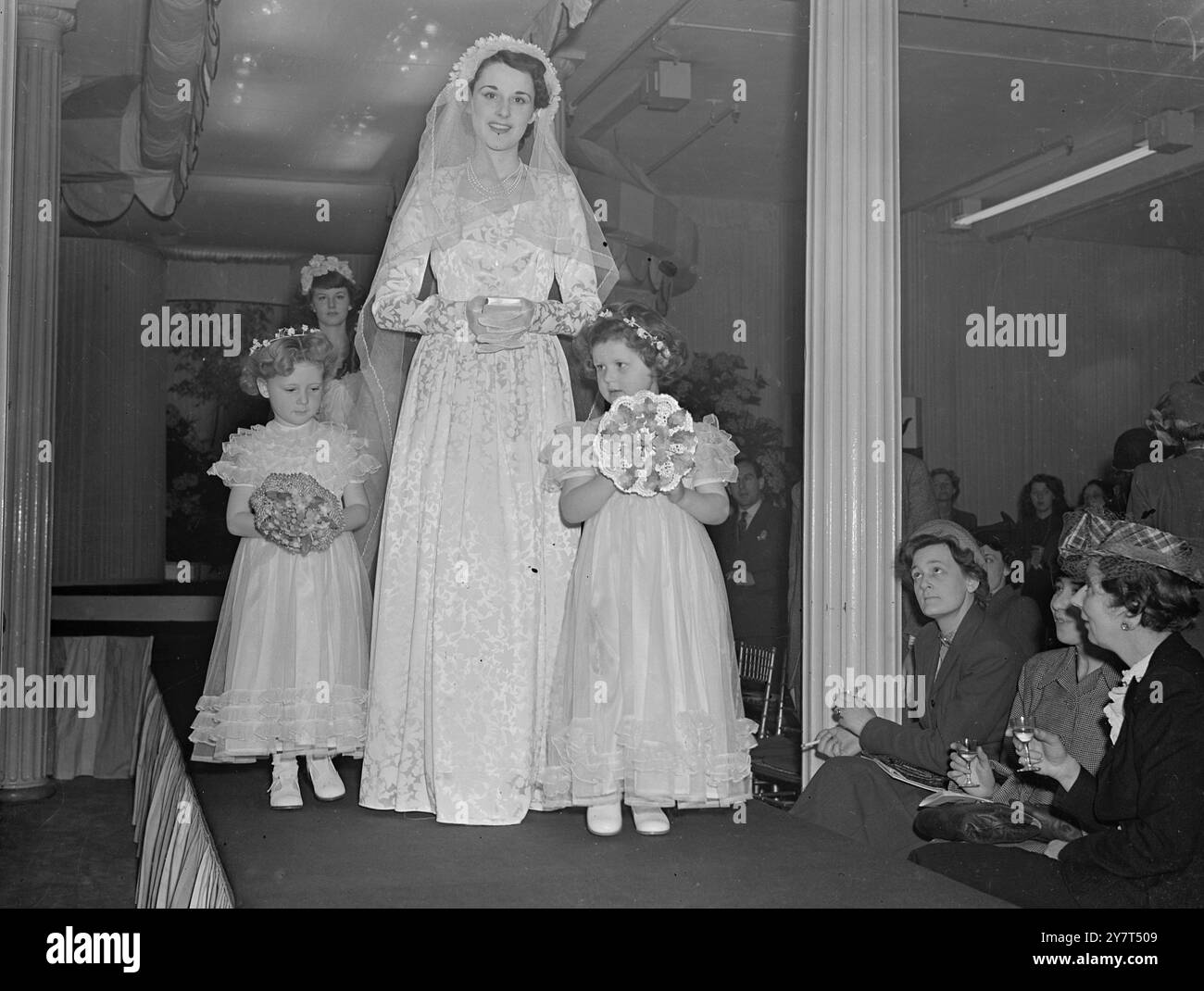 SIMPLICITÉ POUR LA MARIÉE ensemble de MARIÉE vu à un défilé de la mode des femmes et des enfants parrainé par Cooks au 22, St. Paul's Churchyard , Londres . La robe de la mariée en satin gaufré garnie de petits boutons est intitulée ' simplicité ' . Il coûte £12 15s.0d . 2 mai 1949 Banque D'Images