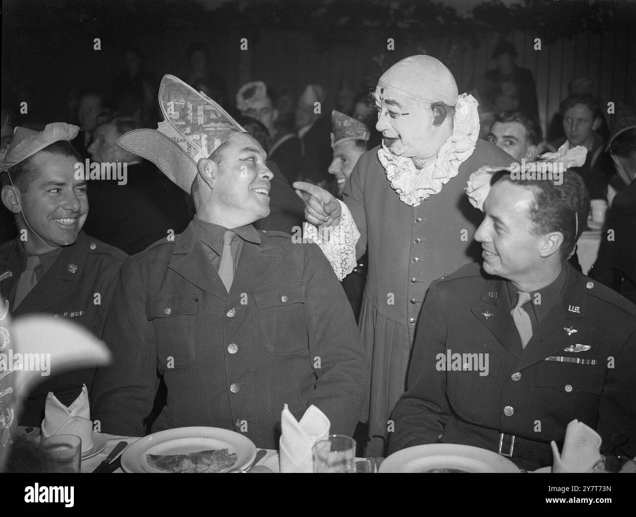 HOMMES COMBATTANTS ALLIÉS DE DEUX GUERRES MONDIALES À BUCKINGHAM PALACE PARTIE 1944 hommes combattants alliés blessés dans cette guerre et 1914-18 ont été invités de l'Association "Not Forgotten" à une grande fête de Noël tenue à la Royal Riding School, Buckingham Palace. La duchesse de Kent était présente. LES PHOTOS MONTRENT:- Argo le Clown blague avec le lieutenant Sanford Bailey de Los Angeles, Californie, et le sergent technique William A. Paschal, de Houston, Texas. 21 décembre 1944 Banque D'Images