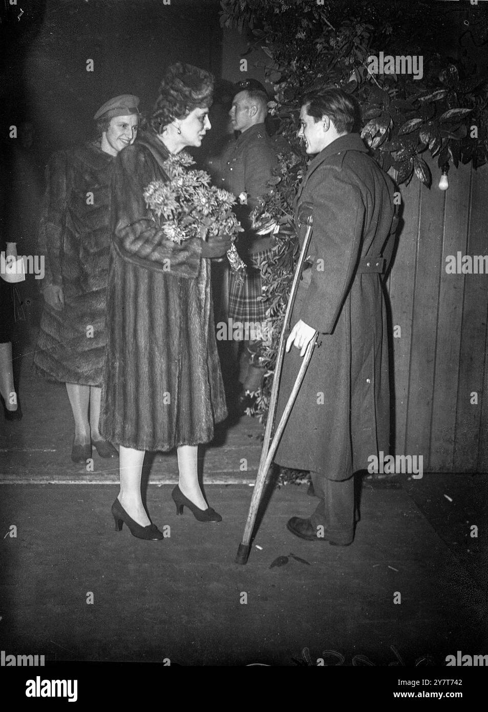 HOMMES COMBATTANTS ALLIÉS DE DEUX GUERRES MONDIALES À BUCKINGHAM PALACE PARTIE 1944 hommes combattants alliés blessés dans cette guerre et 1914-18 ont été invités de l'Association "Not Forgotten" à une grande fête de Noël tenue à la Royal Riding School, Buckingham Palace. La duchesse de Kent était présente. PHOTO MONTRE:- la duchesse de Kent recevant un bouquet du soldat Eugène du bois, de l'armée belge. 21 décembre 1944 Banque D'Images