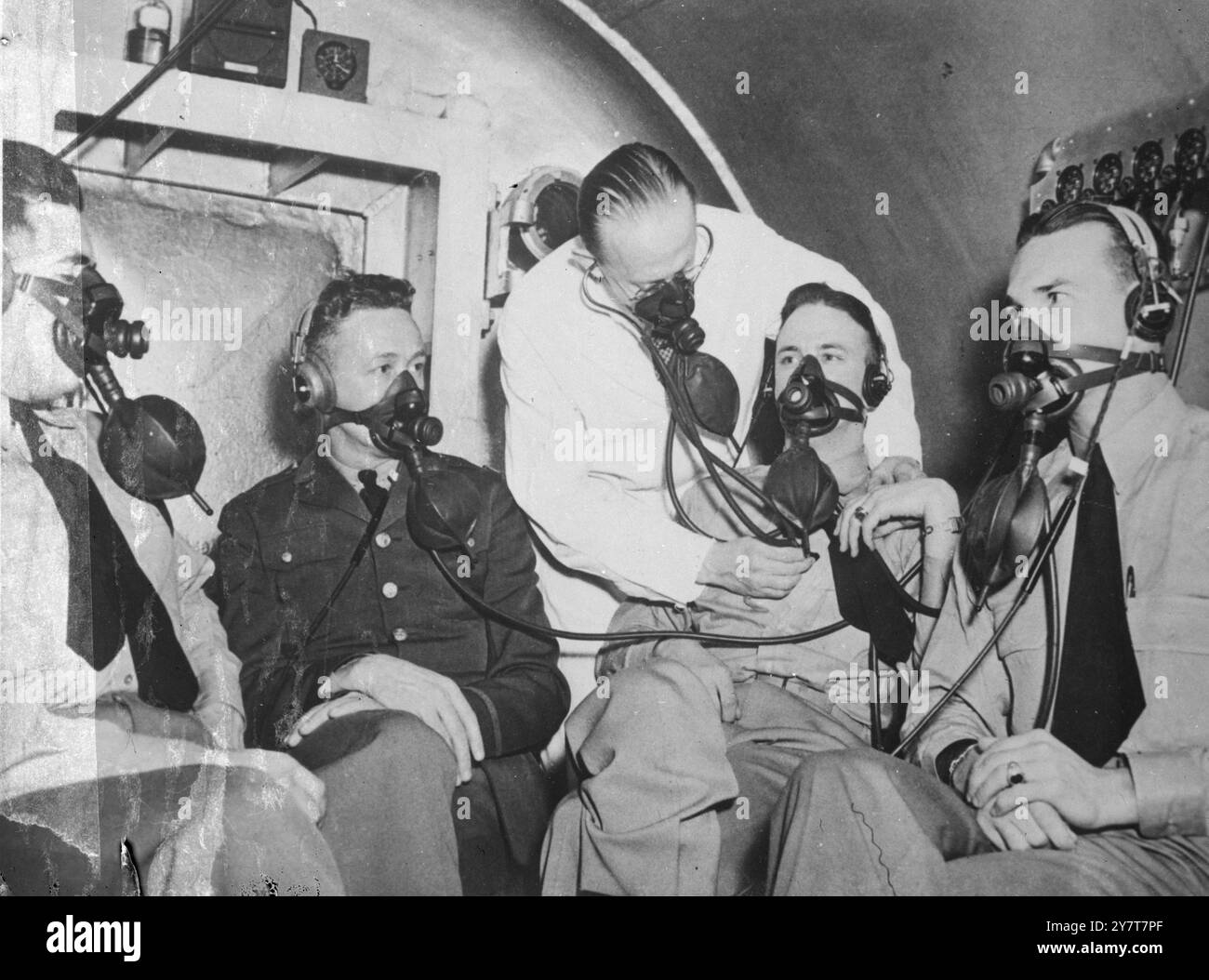 LES AVIATEURS américains S'ENTRAÎNENT POUR LE VOL À HAUTE ALTITUDE - les responsables et les techniciens de l'armée américaine développent des équipements et des hommes pour exécuter avec la plus grande efficacité possible dans l'atmosphère raréfiée au-dessus de 25 000 pieds . Une école a été inaugurée à Wright Field pour cette formation, et les hommes sont reçus 30 à la fois de tous les États-Unis, PHOTO MONTRE:- des étudiants faisant une ascension théorique à 38 000 pieds, dans la chambre de pression de 40 pieds dans le laboratoire de recherche, tandis que le Dr J. W. Hein vérifie leurs battements cardiaques, USA 27 février 1941 Banque D'Images