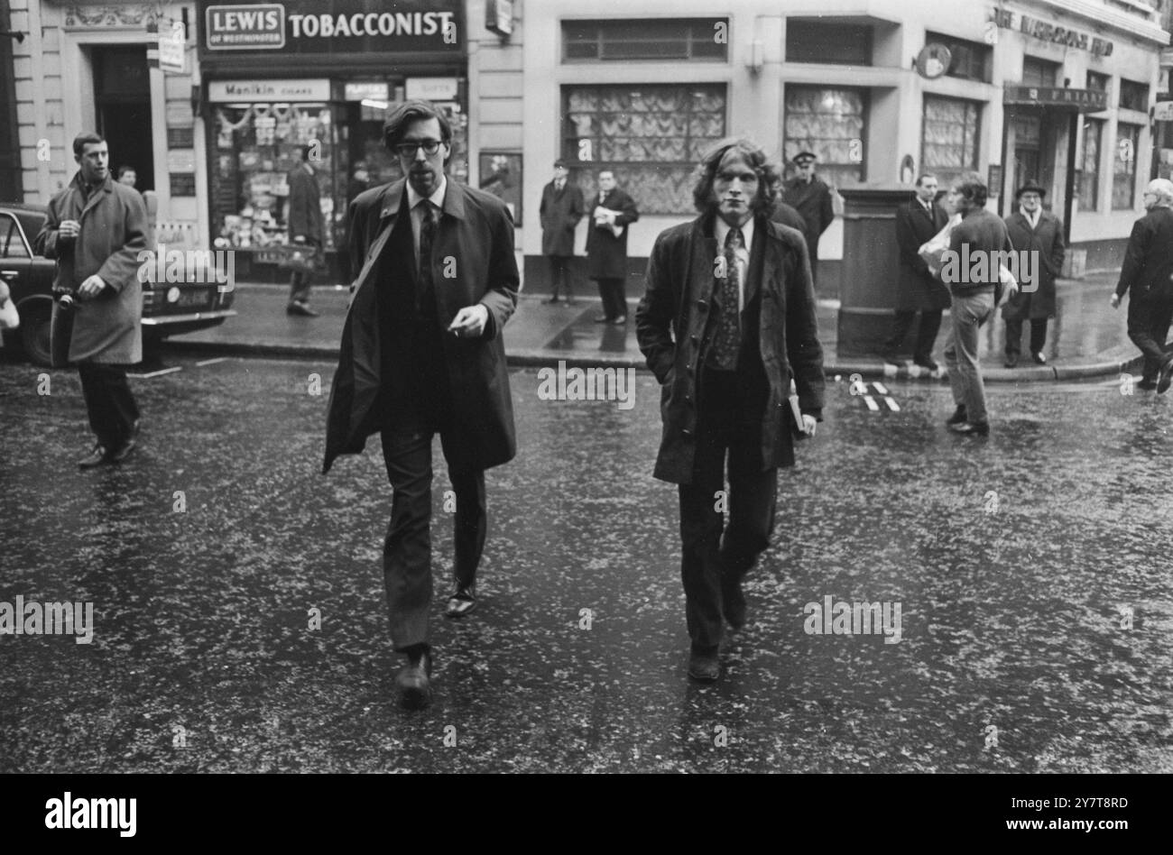 Deux hommes identifiés (peut-être) comparaissant avec quatre autres personnes au tribunal de Marlborough Street , dont Christopher Jagger et Suzy Creamcheese Zeiger , après avoir été arrêtés alors qu'ils protestaient contre la peine de neuf mois de prison prononcée contre Brian Jones , des Rolling Stones , pour délits liés à la drogue. Lors d'un procès précédent, il a été déclaré que Chris Jagger s'était rendu à la manifestation pour apporter un soutien moral à la manifestation. 21 décembre 1967 Banque D'Images