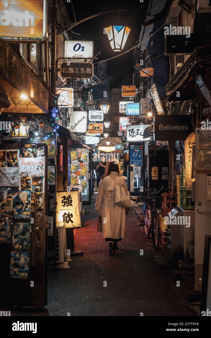 Femme marchant dans une ruelle à shinjuku la nuit Banque D'Images