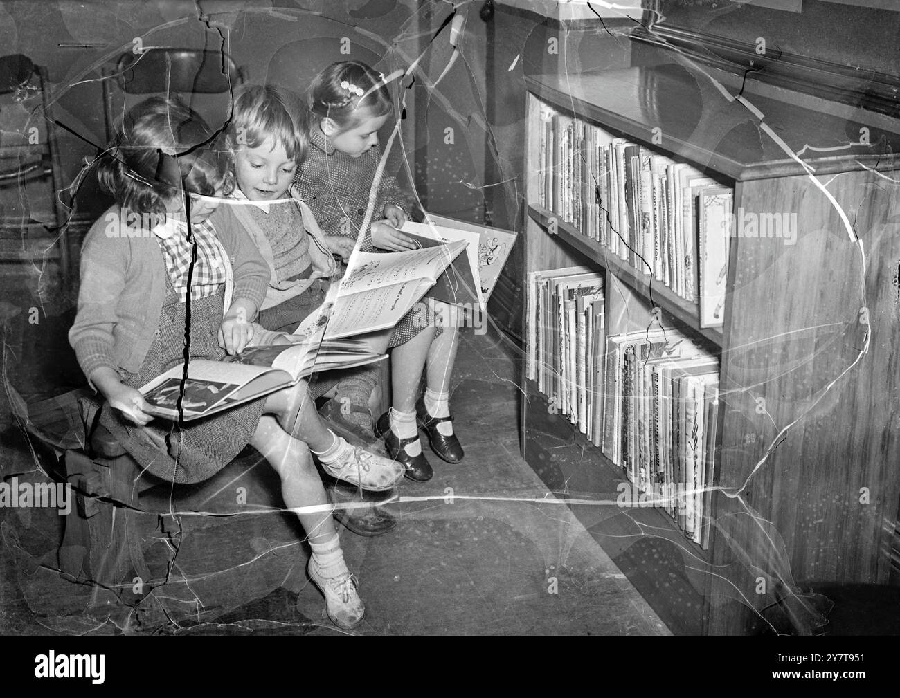 BIBLIOTHÈQUE POUR LES TOUT-PETITS prétendant fièrement avoir les plus jeunes ' emprunteurs ' à Londres est la bibliothèque Bermondsey Central, qui a installé un coin spécial pour les tout-petits . Les livres d'images aux couleurs vives sont empilés dans une bibliothèque naine, il y a des bancs nains spéciaux pour que les petits lecteurs puissent s'asseoir dessus et les images des enfants forment la décoration. Le coin des tout-petits a été introduit après que le bibliothécaire en chef, M. R. Percy Clare , eut remarqué que les enfants âgés de douze ou treize ans visitaient souvent le département des enfants avec des frères ou des sœurs en bas âge à leur charge. Les tout-petits trouvaient ça ennuyeux Banque D'Images