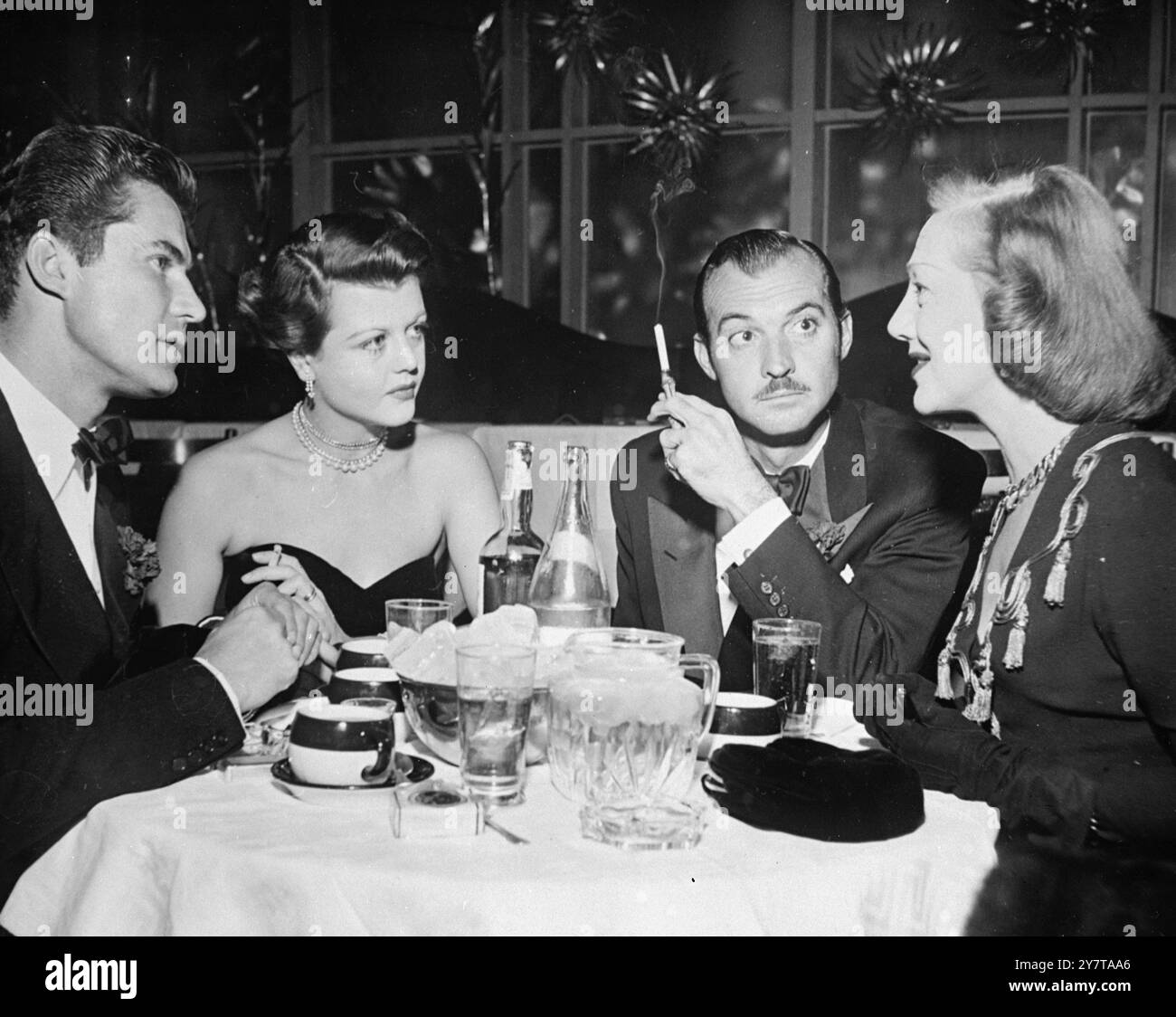 EN ÉCOUTANT GERTRUDE le 15 mai 1950, l'actrice Gertrude Lawrence (à droite) attire l'attention d'un public de trois personnes au Ciros à Hollywood. De gauche à droite se trouvent Peter Shaw, designer acteur anglo-irlandais, sa femme, l'actrice britannique Angela Lansbury, et l'acteur Zachary Scott. Peter Shaw et Angela Lansbury se sont mariés à Londres en août dernier Banque D'Images