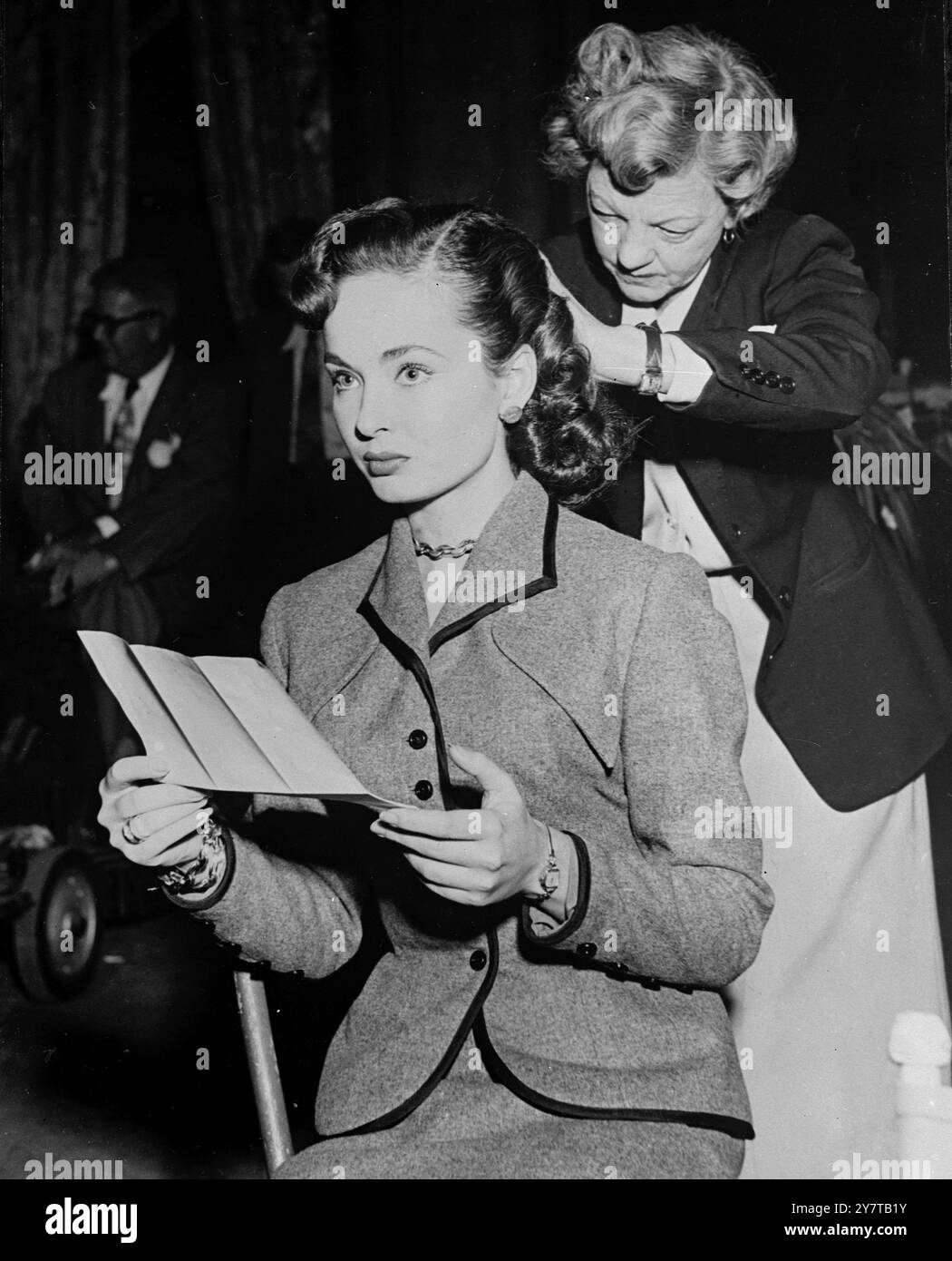 SILVER SCREENS BUSY MISS 28 avril 1950 comme la plupart des stars de l'écran de travail, Hollywoods Ann Blyth a un horaire tellement chargé de tournage, constumation et répétition qu'elle n'ose pas perdre un moment. Elle est photographiée ici alors qu'elle vérifie une partie du courrier du matin tandis que le coiffeur de studio applique des touches de dernière minute à sa coiffure. Banque D'Images