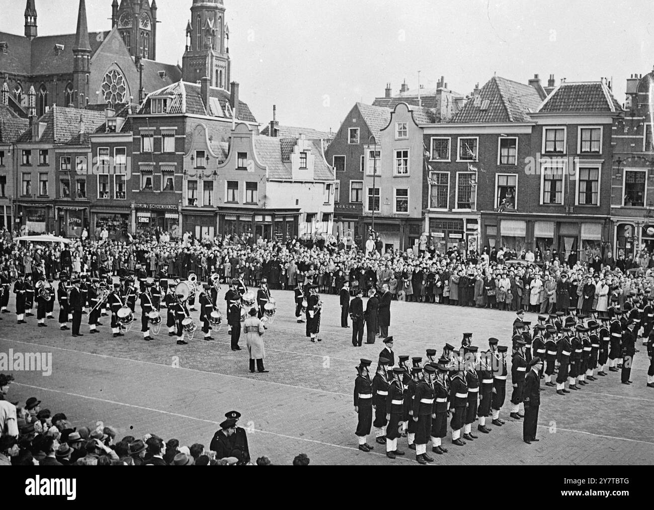 CADETS BRITANNIQUES EN HOLLANDE - - 11 avril 1950 - - avec l'architecture médiévale aromatisée à l'arrière-plan et la foule de touristes néerlandais regardant, le corps des cadets de la mer de Kingston upon Thames se tient fermement à l'attention pour inspection devant l'hôtel de ville sur la place du marché de Delft, en Hollande. Les Cadets en visite, marchèrent à travers la ville. Banque D'Images