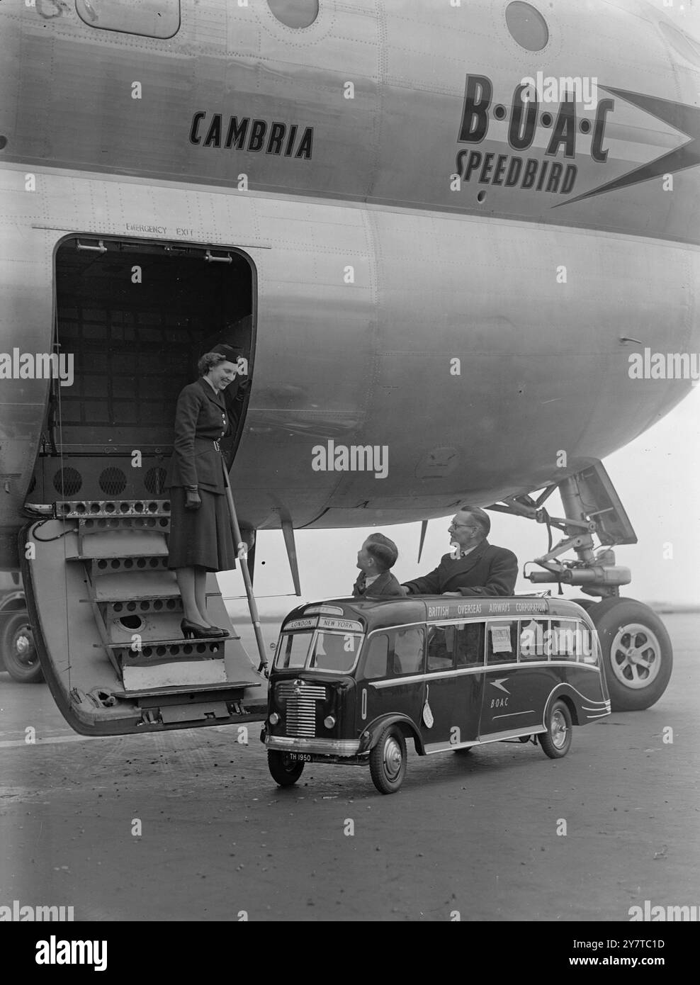 BRITISH MINI AUTOCAR VOLE VERS L'AMÉRIQUE POUR AIDER LE DOLLAR DRIVE4 avril 1950 dernière nouveauté dans l'automobile et un exemple de l'artisanat britannique dans la construction d'autocars, cet autocar miniature Harrington est vu contre l'énorme volume d'un paquebot British Overseas Airways à l'aéroport de Londres aujourd'hui (mardi) alors qu'il était sur le point de partir par avion BOAC pour l'Amérique, où il sera exposé à la foire automobile de New York. L'autocar transporte deux enfants, ou un adulte, en plus du conducteur, a un moteur Villiers refroidi par air de 125cc qui donne une vitesse maximale de 26 miles à l'heure, une vitesse de croisière de 15 miles à l'heure et Banque D'Images